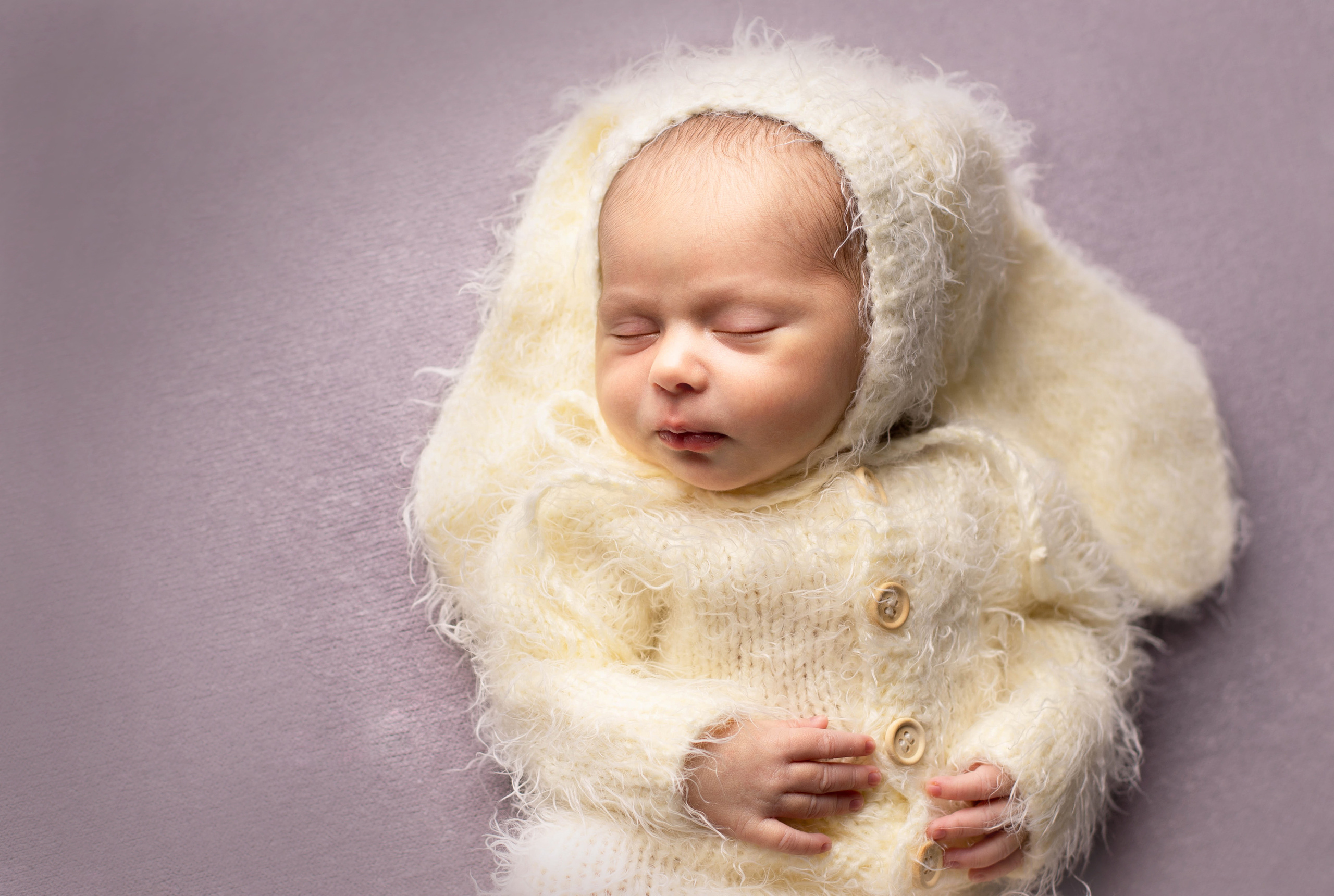 Фотография новорожденного малыша в костюме зайчонка