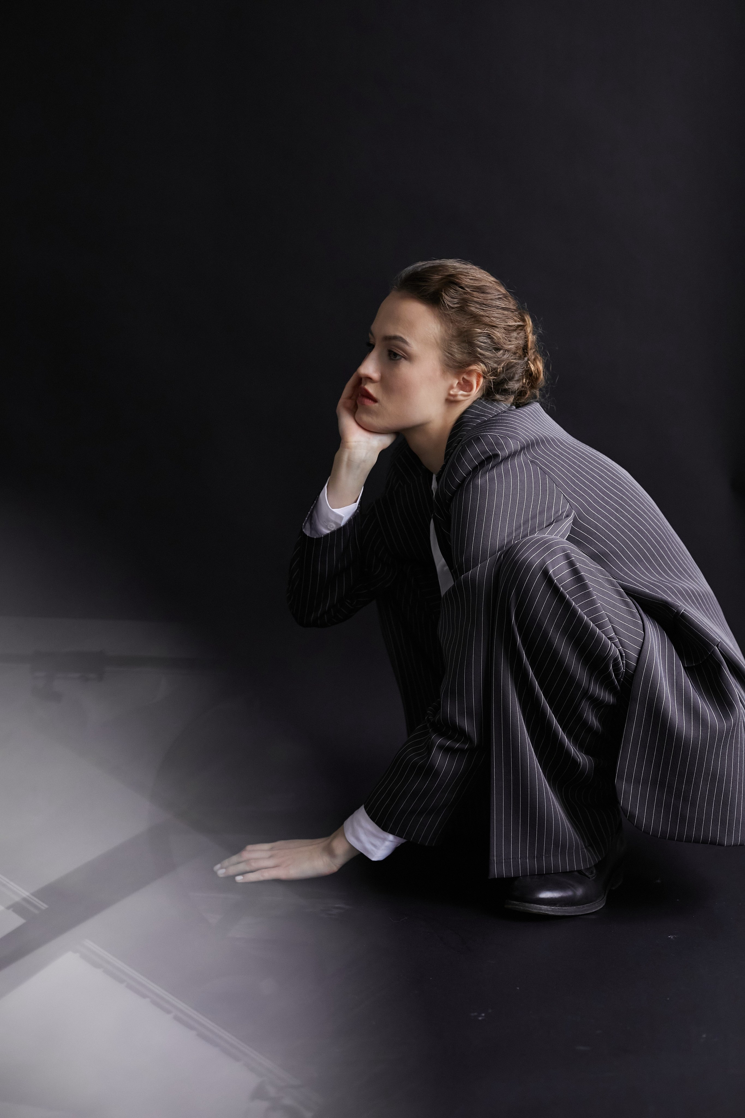 Фотограф в Москве. Студия. Студийный портрет. Девушка в пиджаке. Девушка на стуле на черном фоне. Красивая девушка в мужском костюме. Женский портрет.