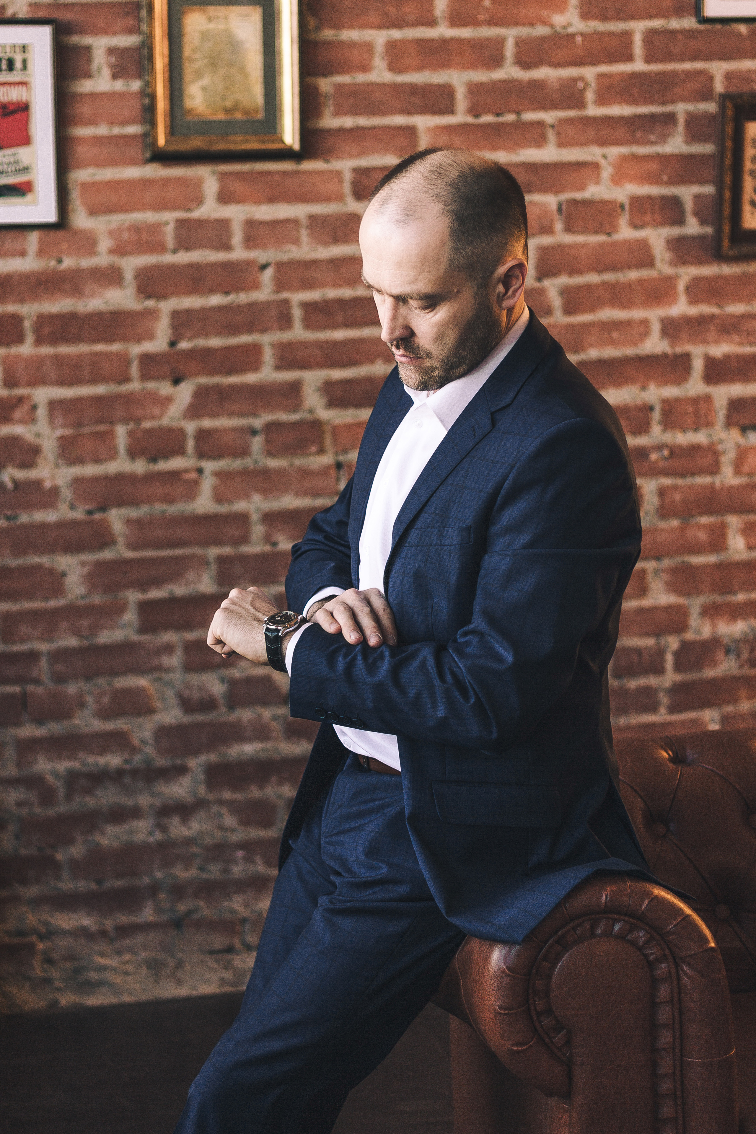 Мужчина в синем деловом костюме смотрит на часы