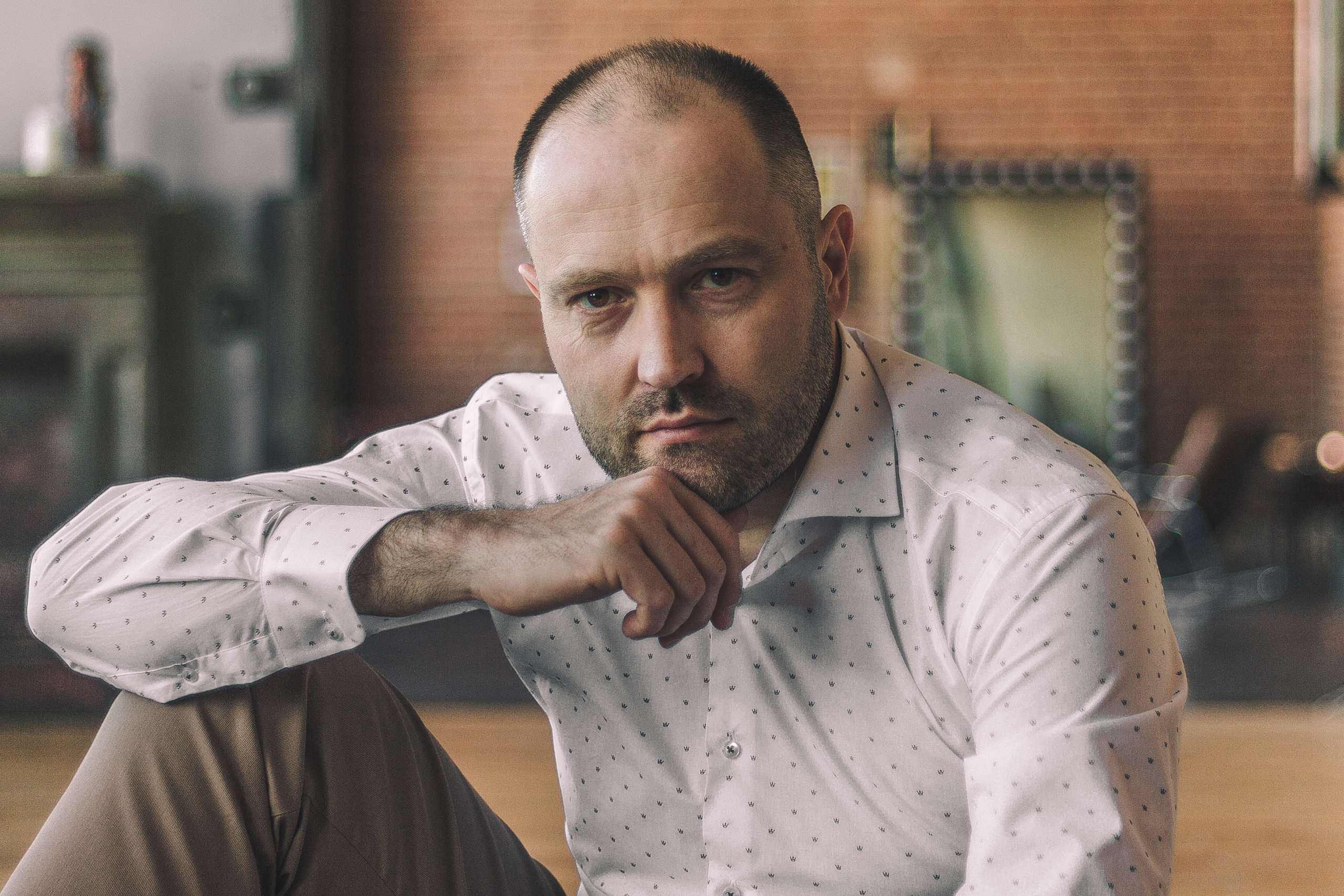 Мужчина в рубашке улыбается и смотрит в камеру