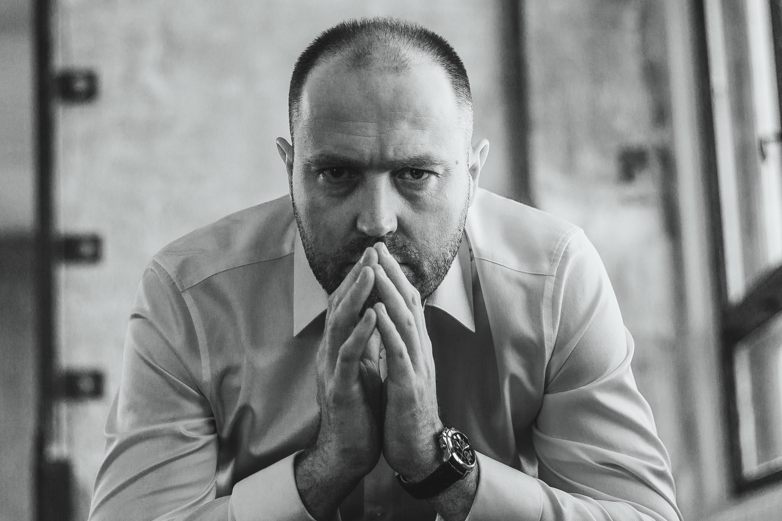 Мужчина в рубашке сидит у окна