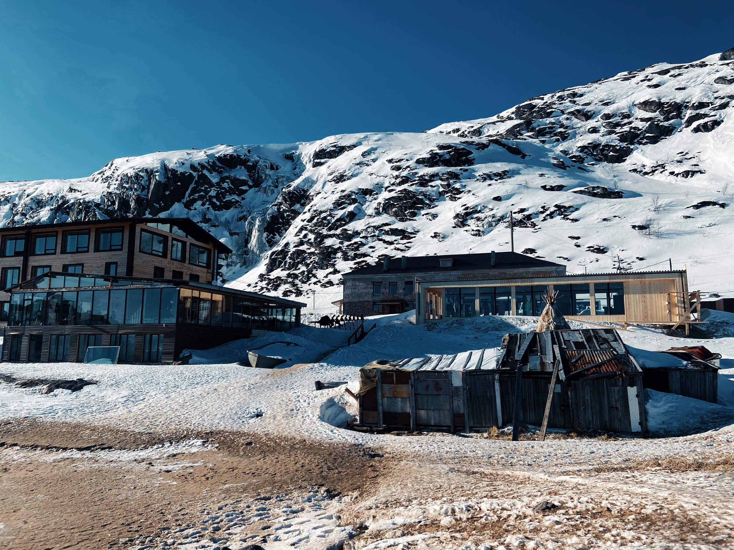 село Териберка зимой, жилые постройки на фоне гор