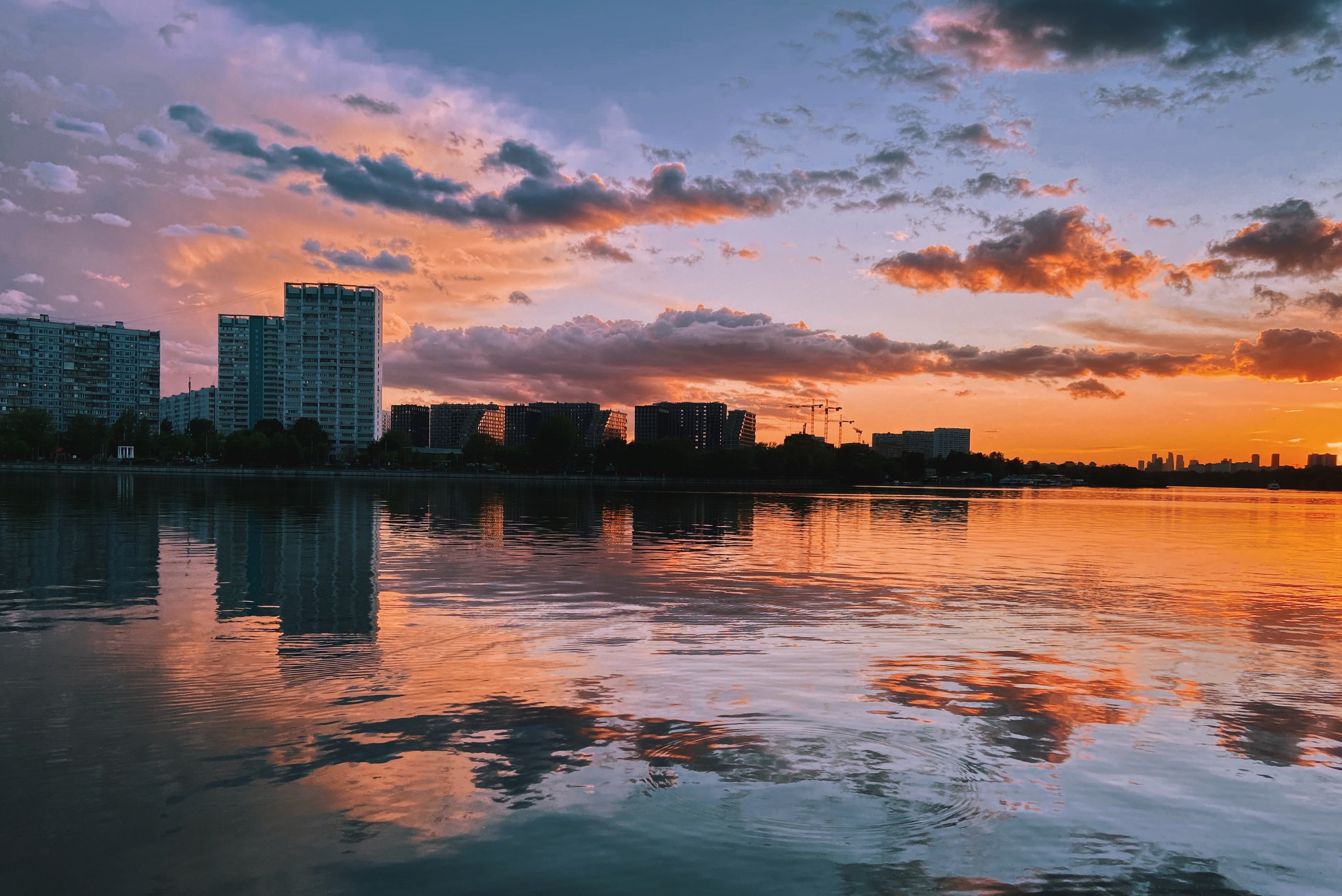 панельные дома на фоне вечернего неба, с облаками розового и фиолетового цвета, летний городской пейзаж, закат на воде, река Москва, вид на нагатинский затон, район Печатники,  Москва