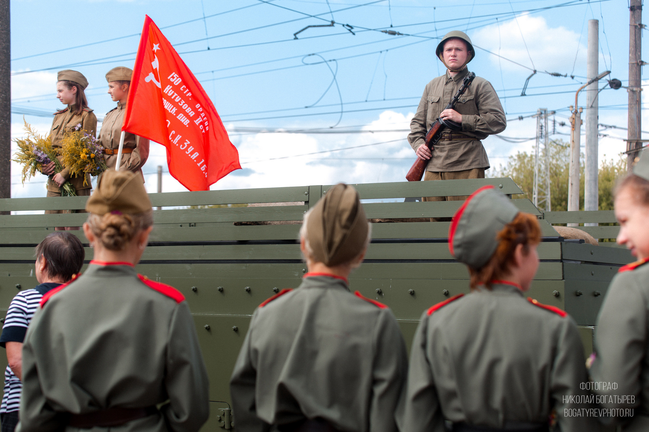 группа военнослужащих в военной форме смотрит на зеленый поезд