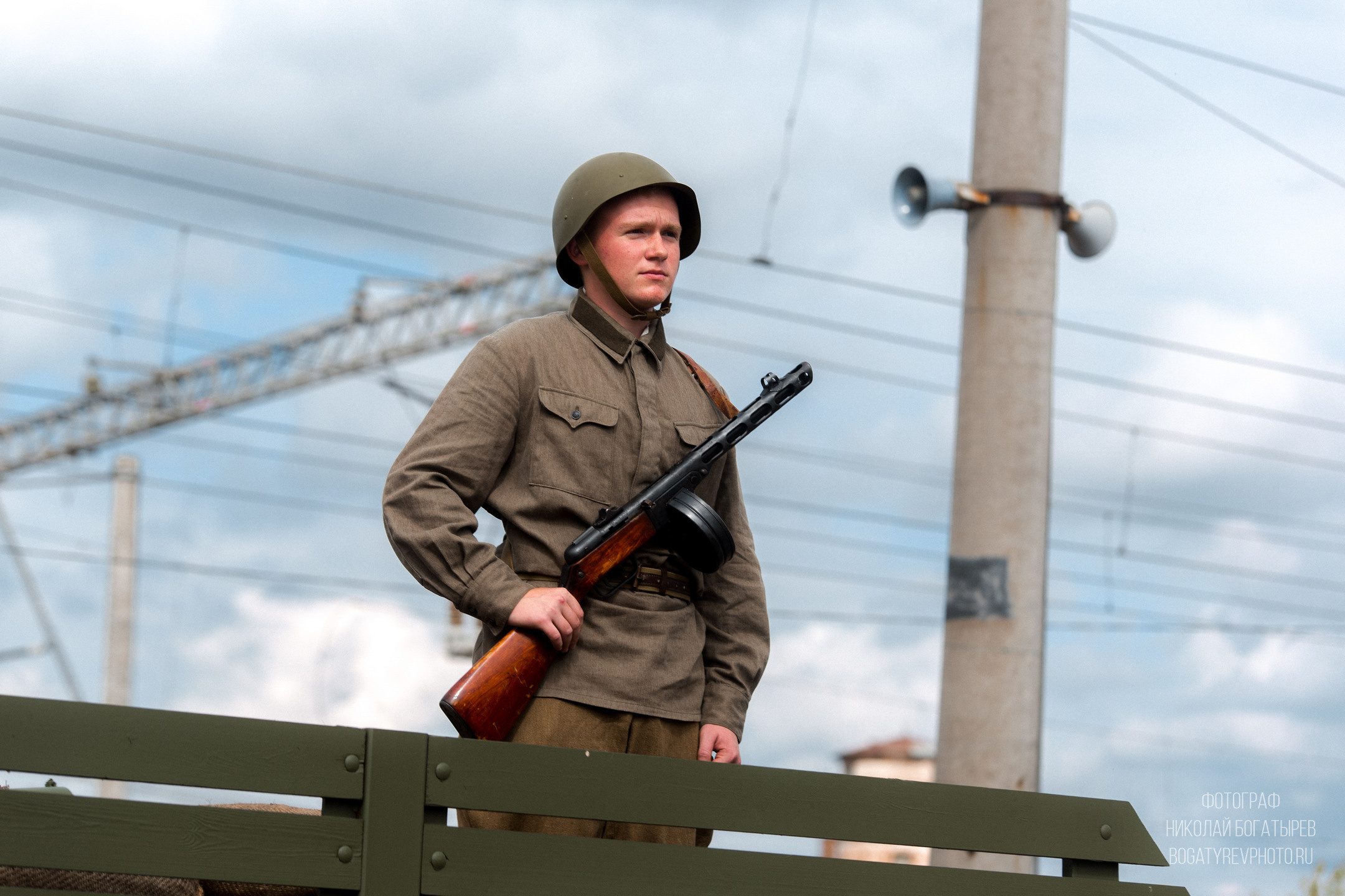 военный офицер . военный офицер с черным пистолетом в руках на деревянном заборе на заднем плане