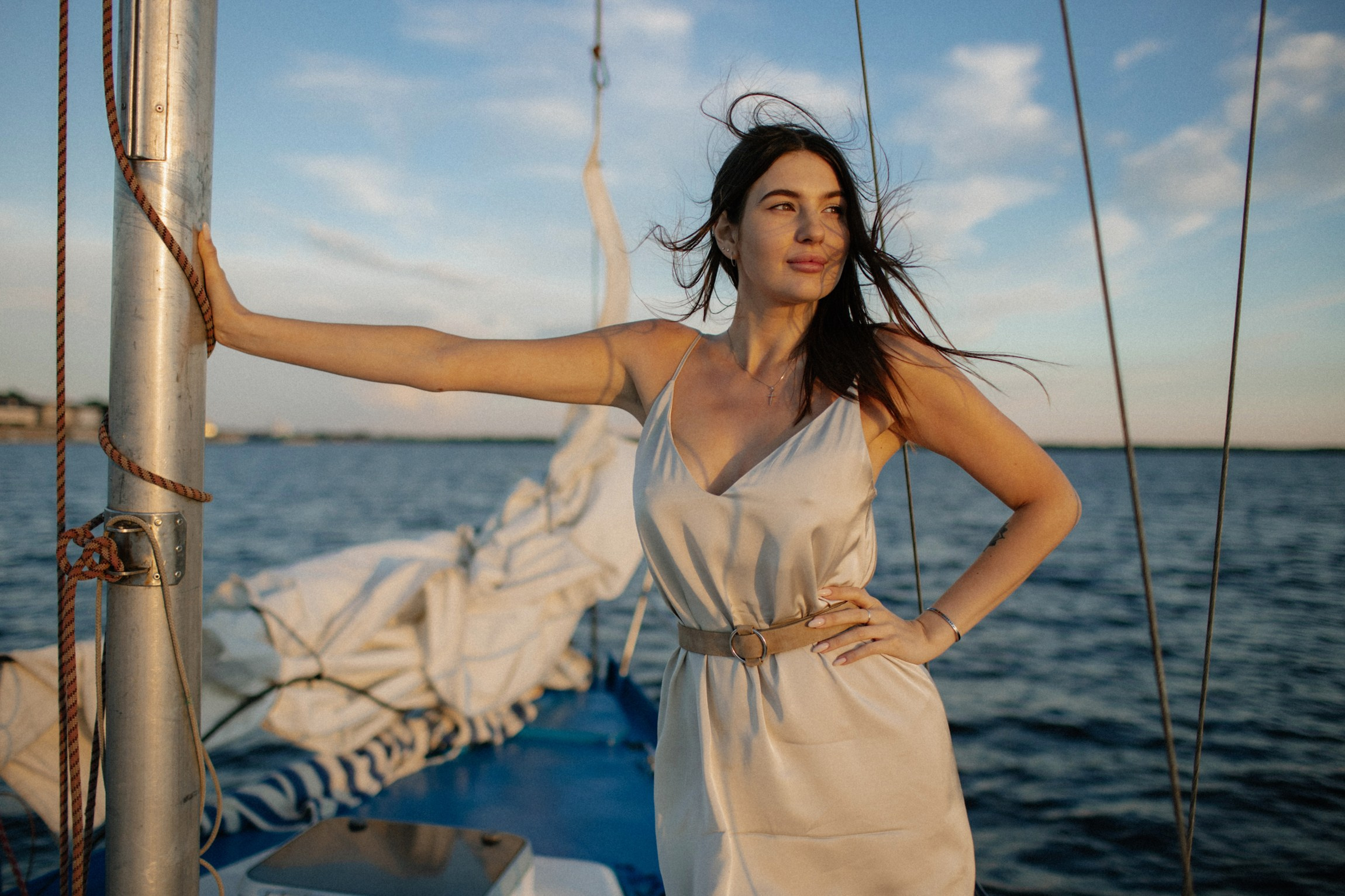 Элегантная красавица в шелковом платье улыбается любимому мужчине возле мачты белого парусника, наслаждаясь видами Архангельска и запахом моря. Фотография выполнена Алексеем Клещиновым.  