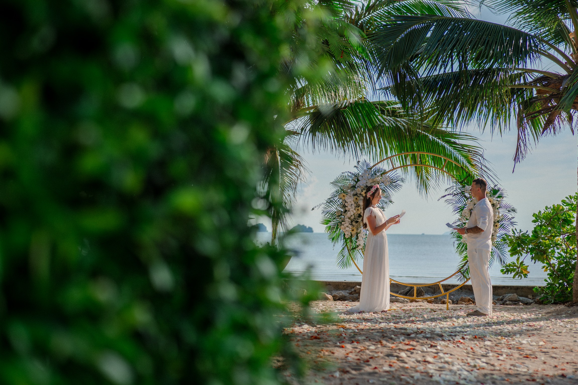 Bride and groom during a romantic beach wedding ceremony on Koh Samui, Thailand, surrounded by tropical scenery and ocean views