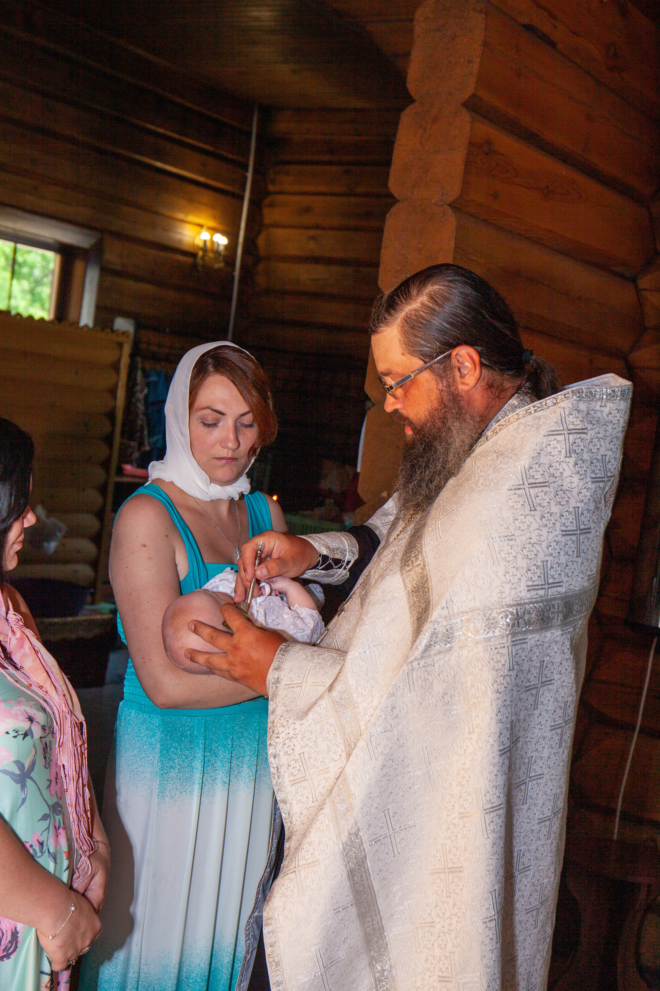 Священник крестит ребенка