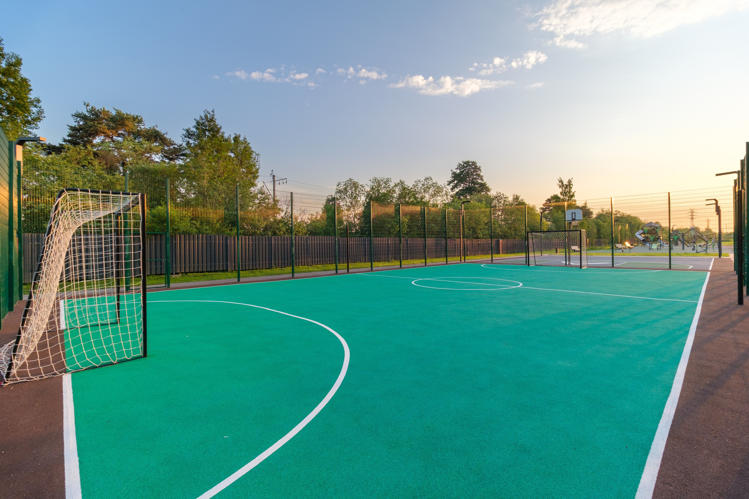 Спортивная площадка, расположенная на улице. Окружена специальным забором-сеткой.