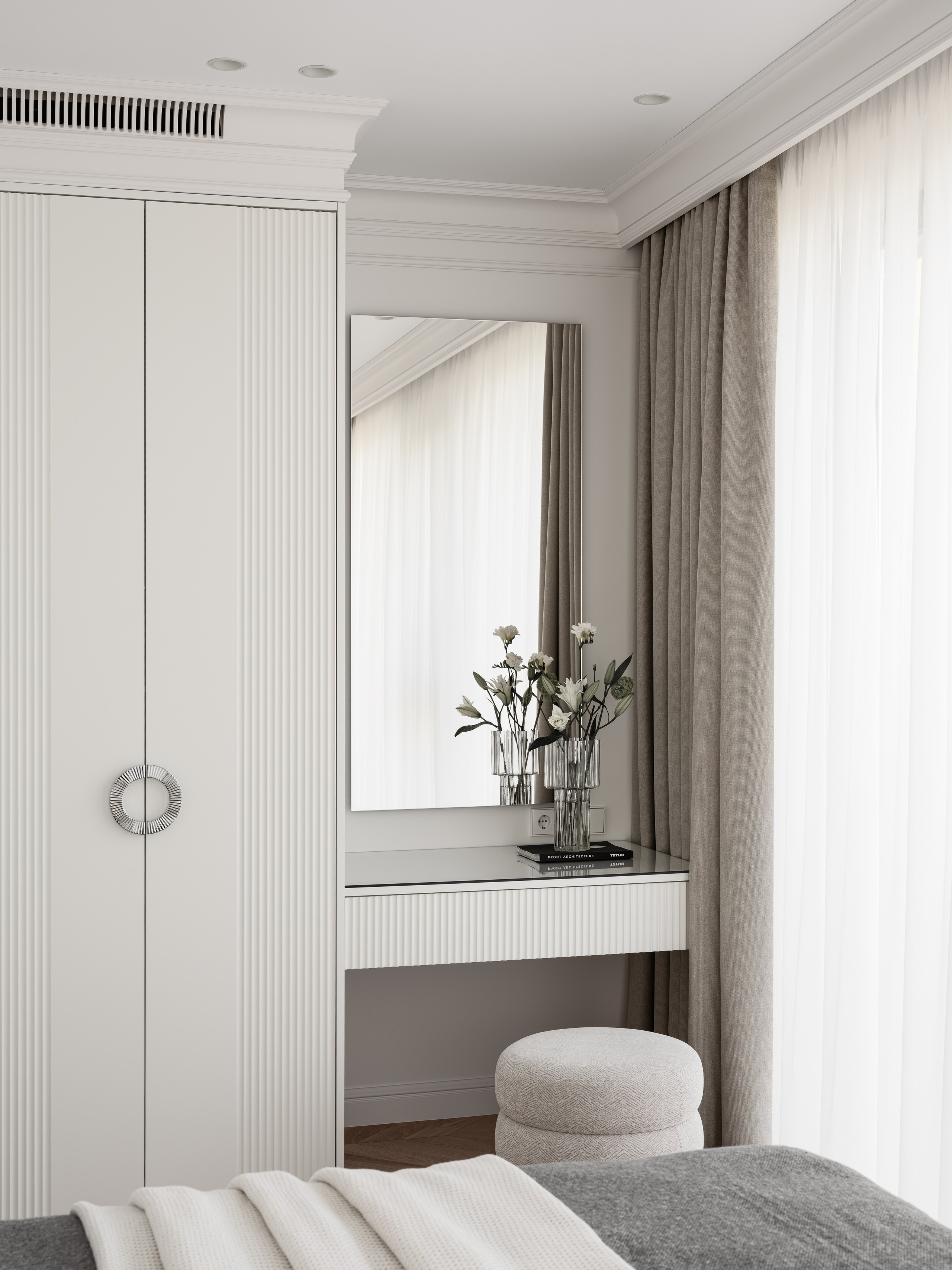 Светлая спальня с туалетным столиком и мягким пуфом у окна, декорированная в современном минимализме дизайнером Алёной Боярской. Наталья Якушева добавила текстильные акценты, а фотограф Сергей Денисенко передал мягкое дневное освещение и чистую геометрию пространства.