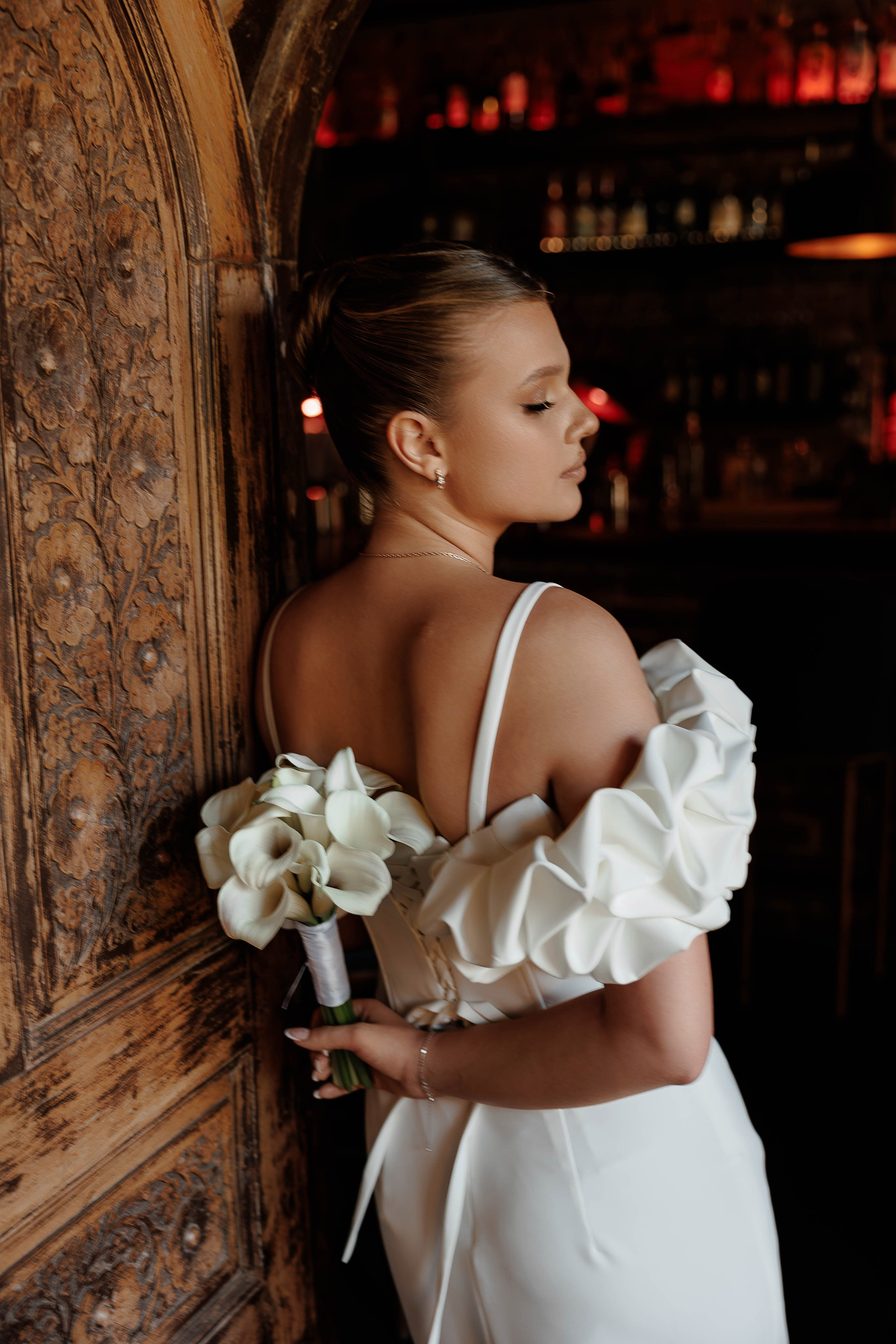 Невеста держит свадебный букет за спиной в ресторане Top WINE в Воронеже