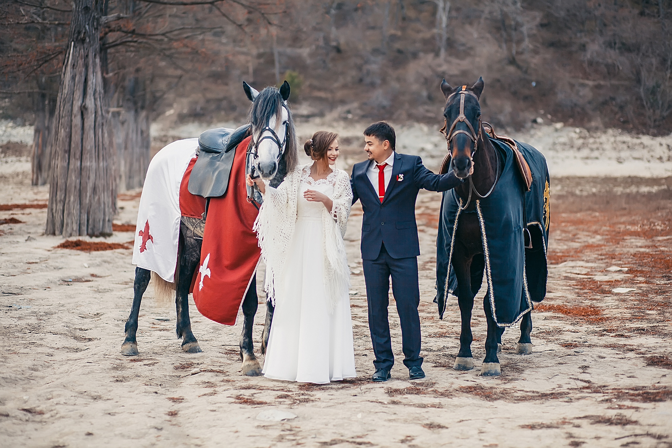 Жених и невеста стоят рядом с лошадьми