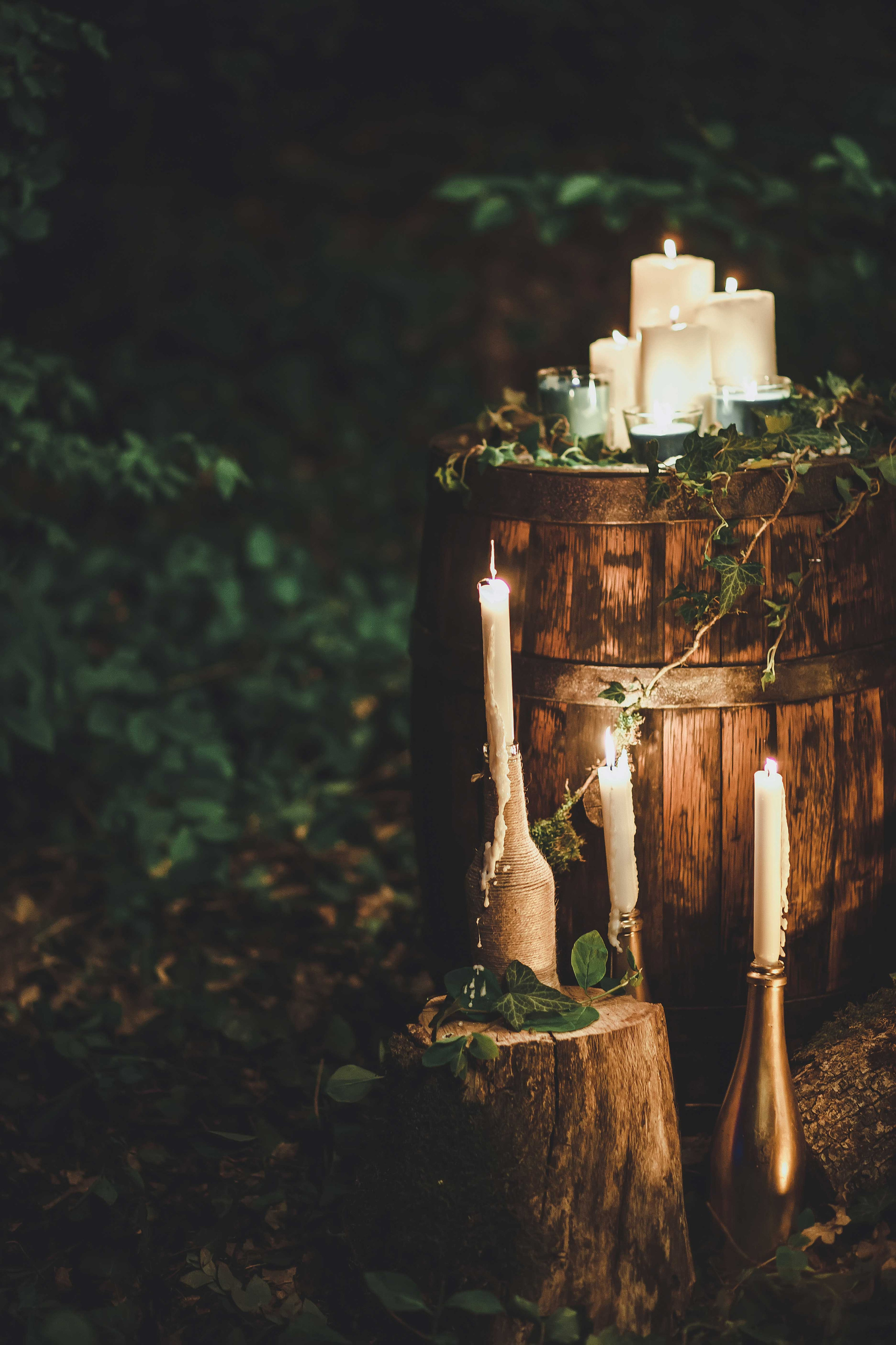 Невеста в голубом свадебном платье с каштановыми распущенными волосами ночью в лесу украшенном гирляндами