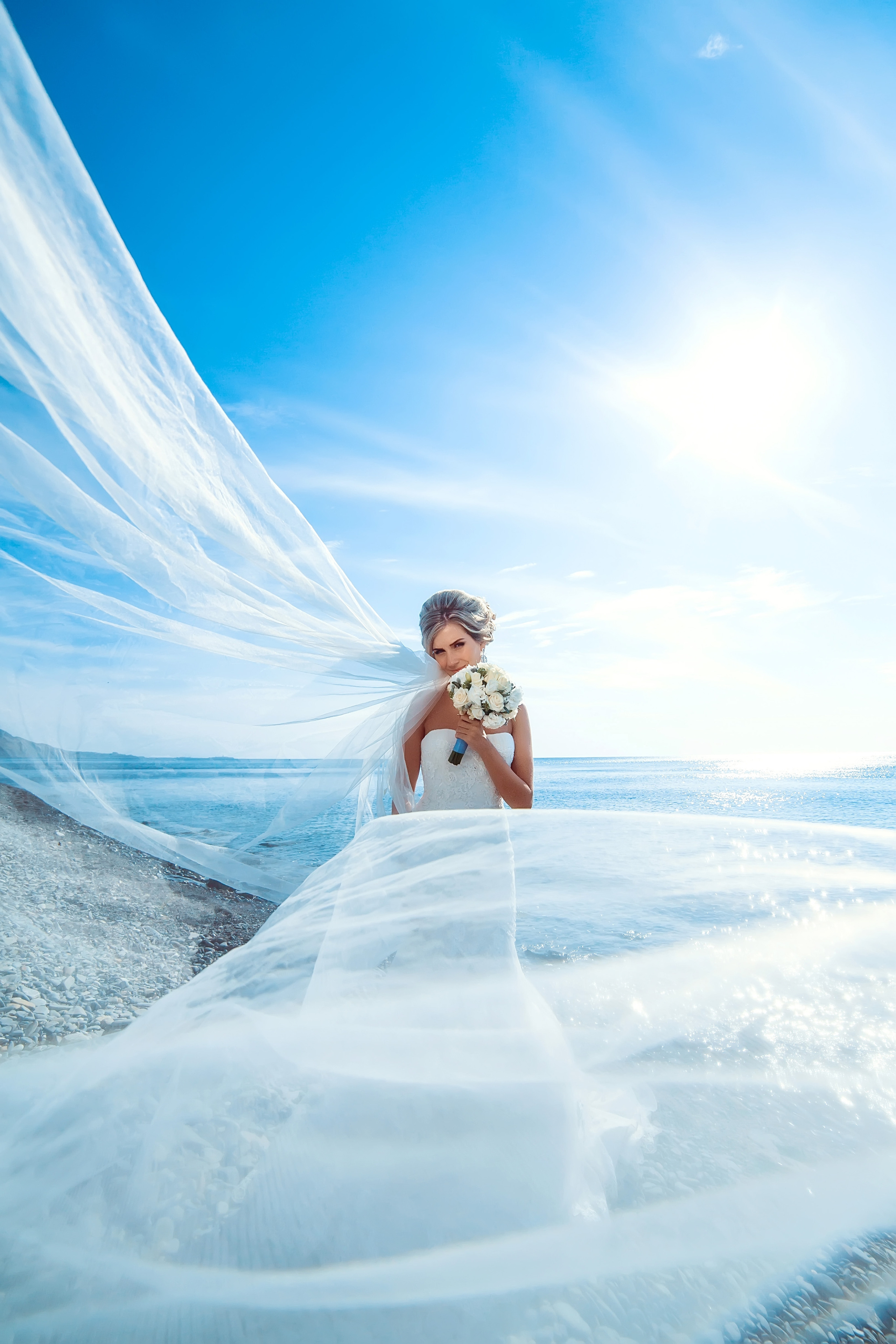 Красивая невеста стоит на фоне моря 