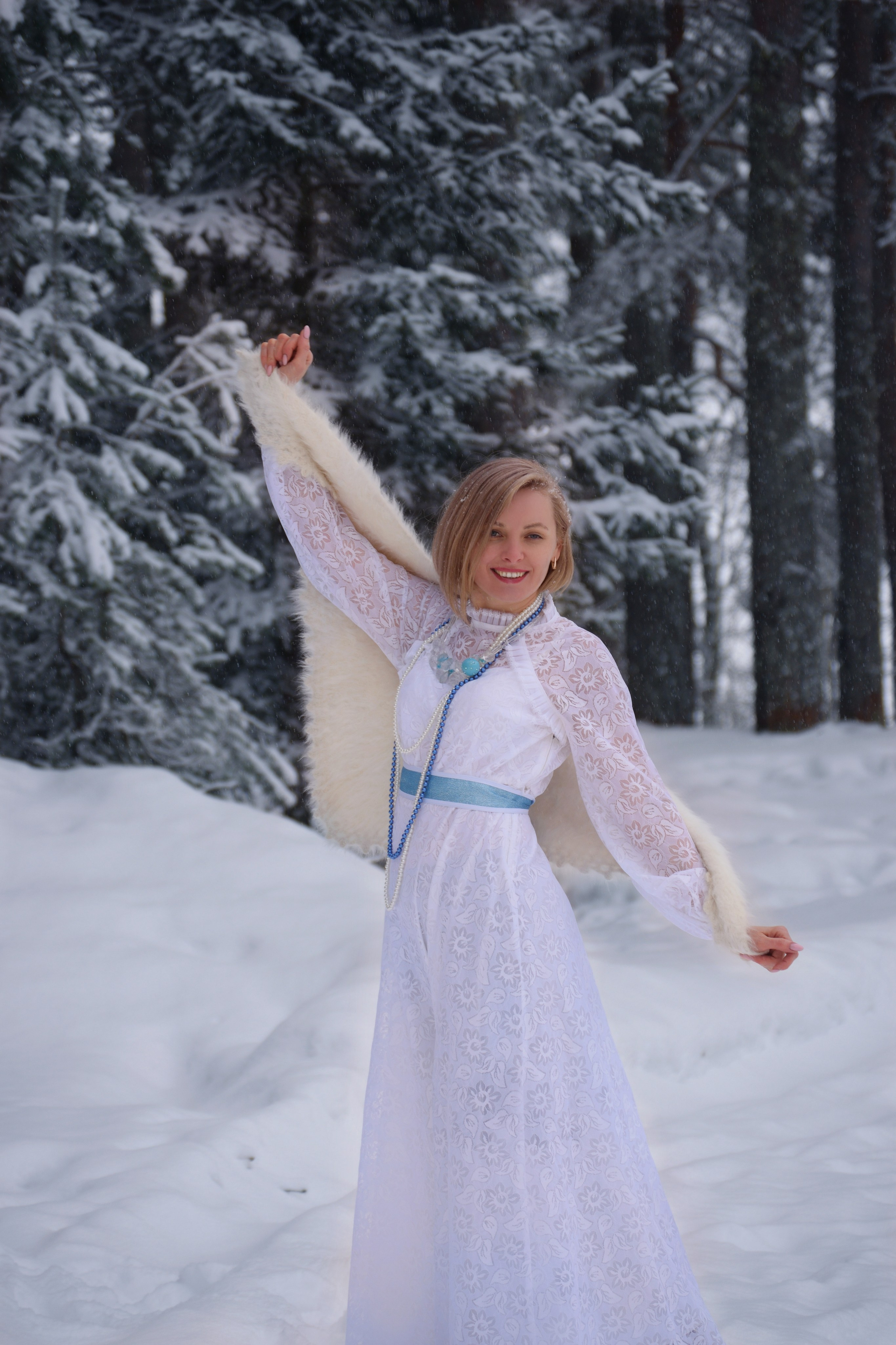 Свадебная фотосъемка в зимнем карельском лесу. Невеста с пуховым платком на плечах.