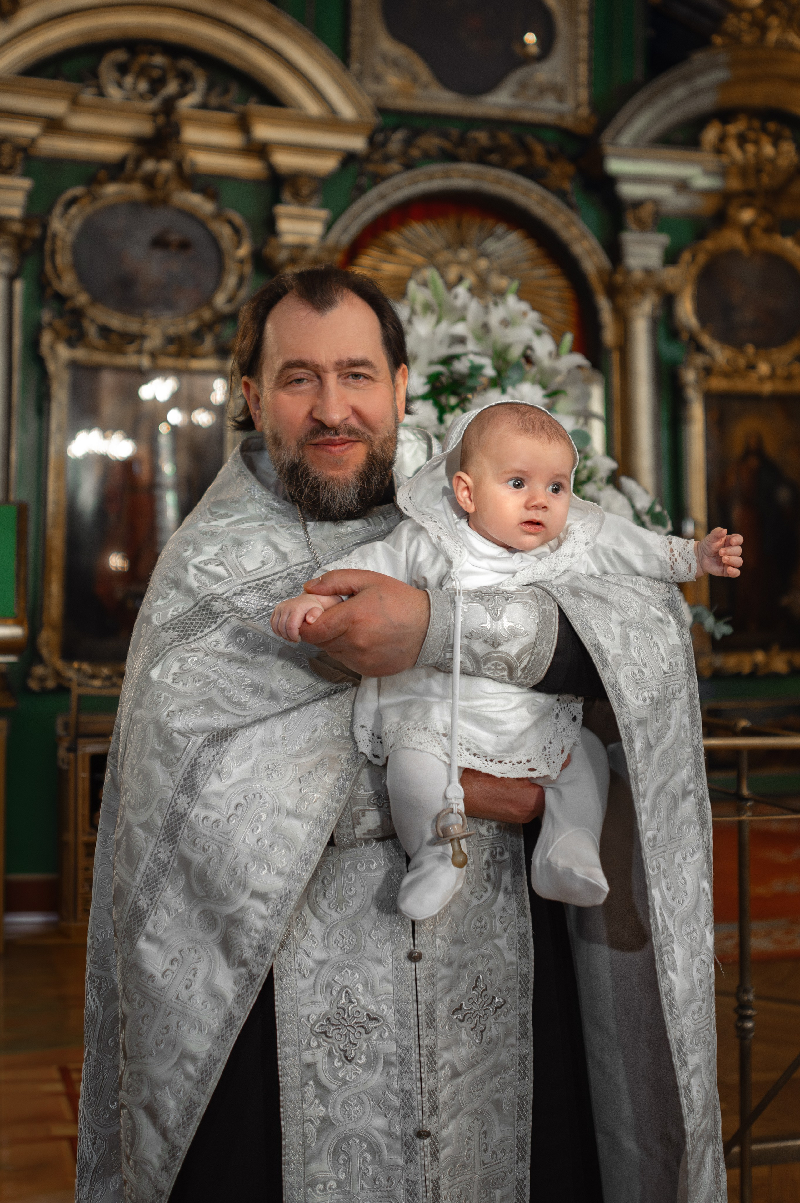 портрет священника, держащего на руках малыша