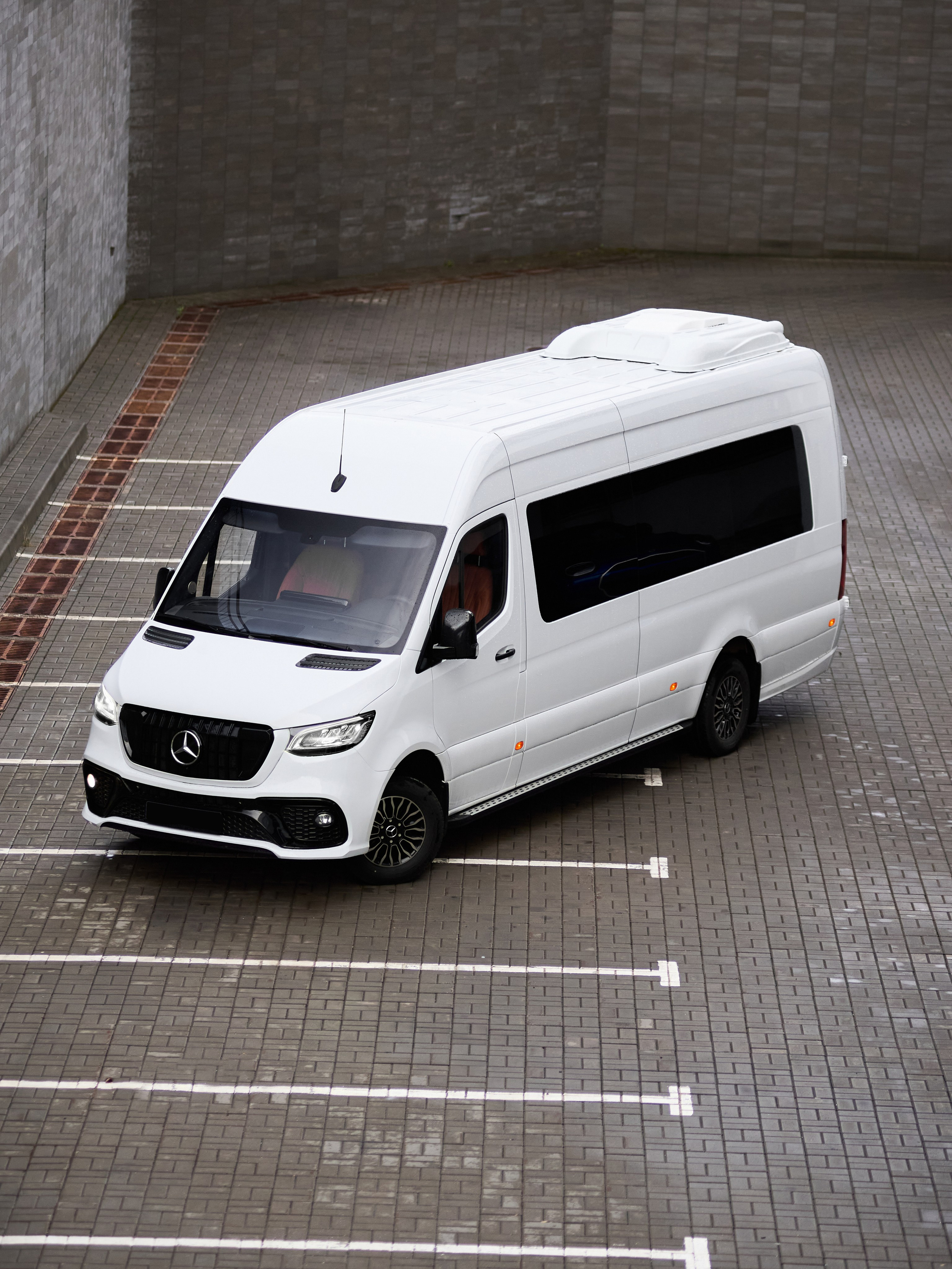 Mercedes-Benz Sprinter тюнинг, вид сверху на белый микроавтобус на парковке у современного здания