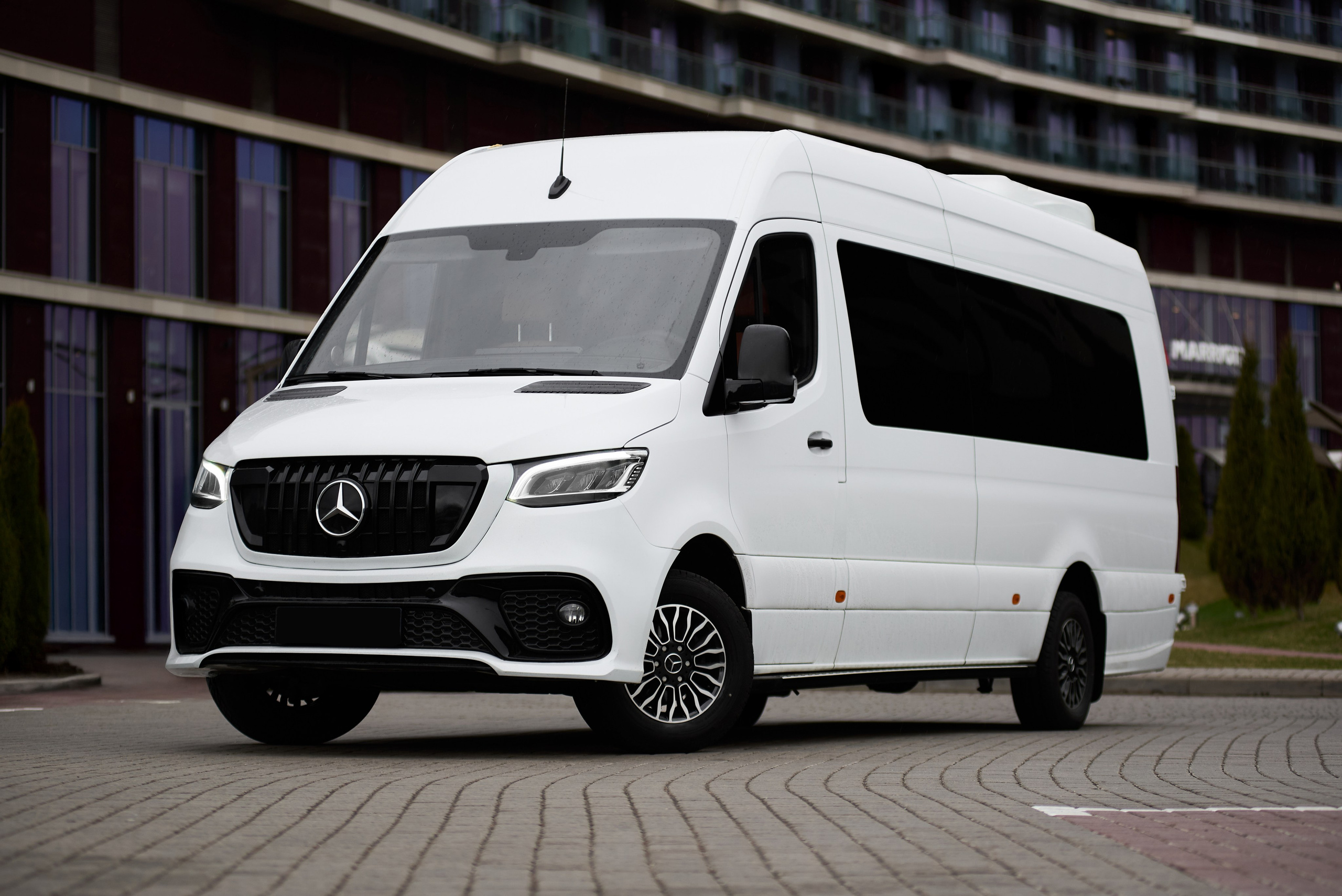 Mercedes-Benz Sprinter тюнинг, передний левый ракурс на парковке у современного здания