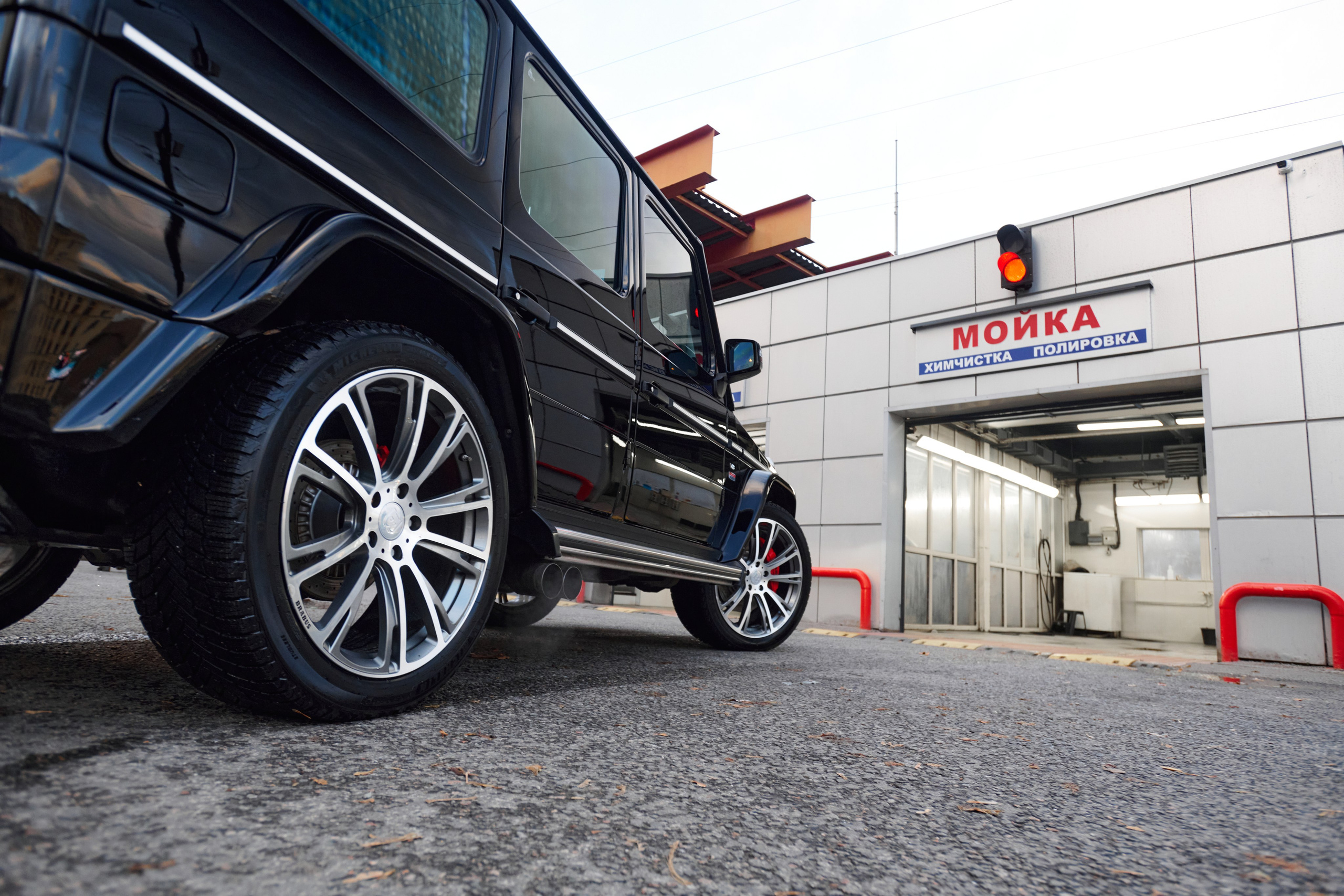 Низкий ракурс Mercedes-Benz G-Class с акцентом на колёса и кузов у автомойки