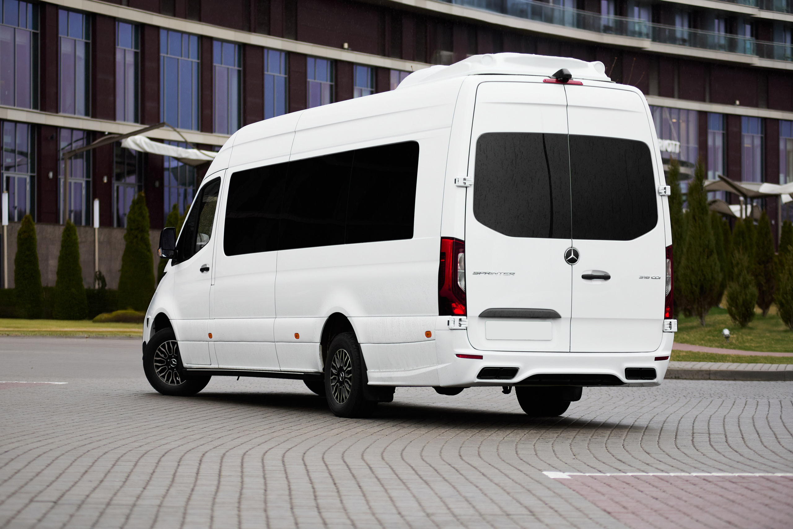 Mercedes-Benz Sprinter тюнинг, задний правый ракурс на площадке у современного фасада