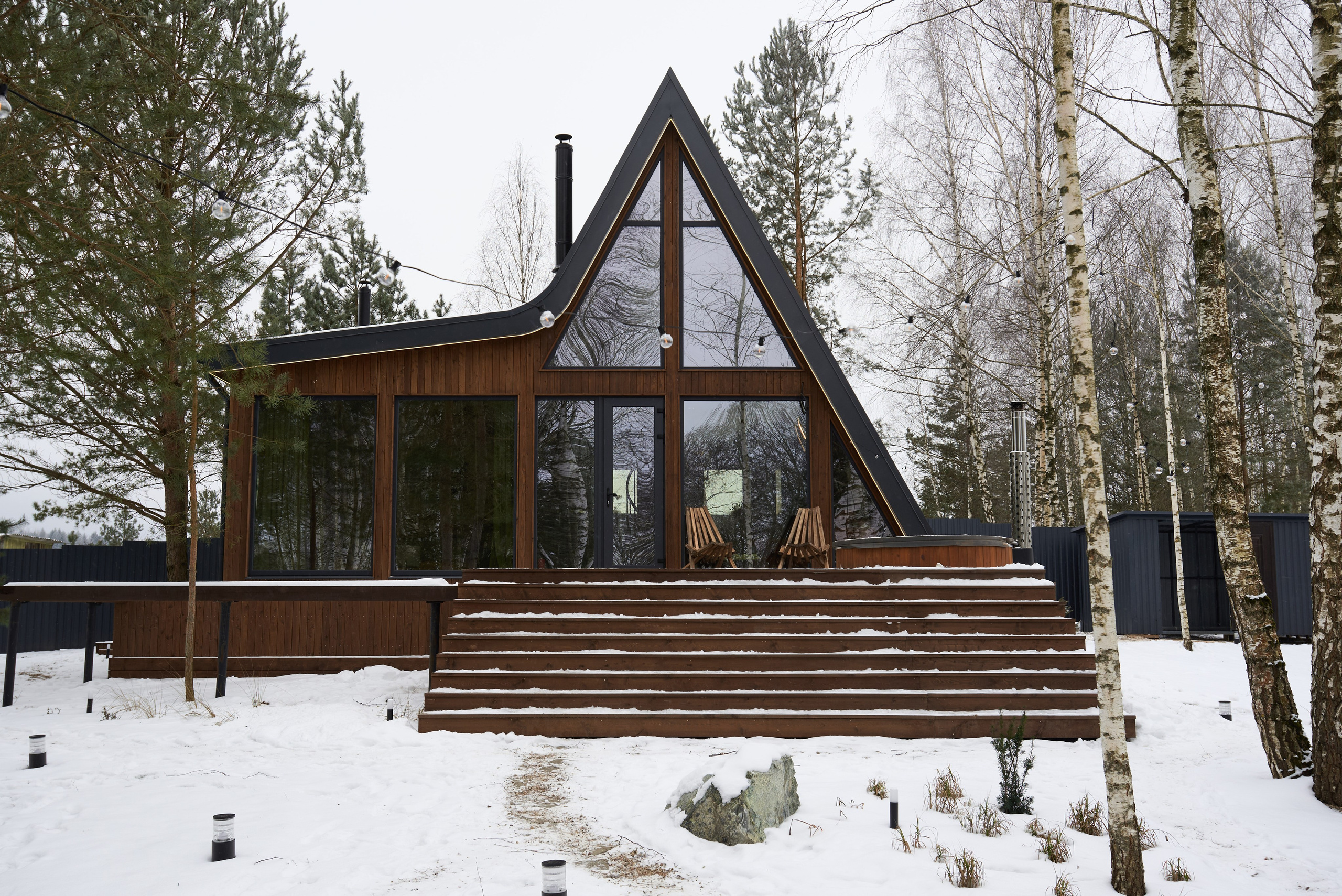 Архитектурная съёмка A-frame дома под Минском с панорамным фасадом, террасой и зимним ландшафтом