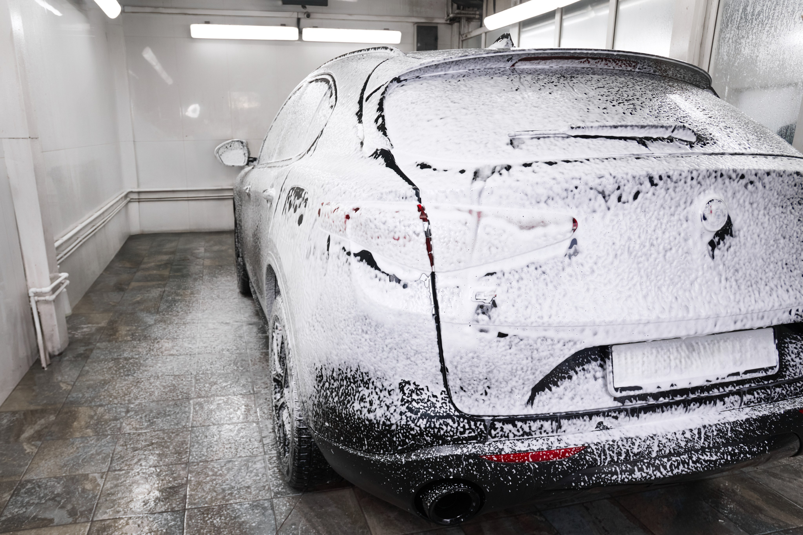 Фотосъёмка Alfa Romeo Stelvio сзади в пене после нанесения автошампуня