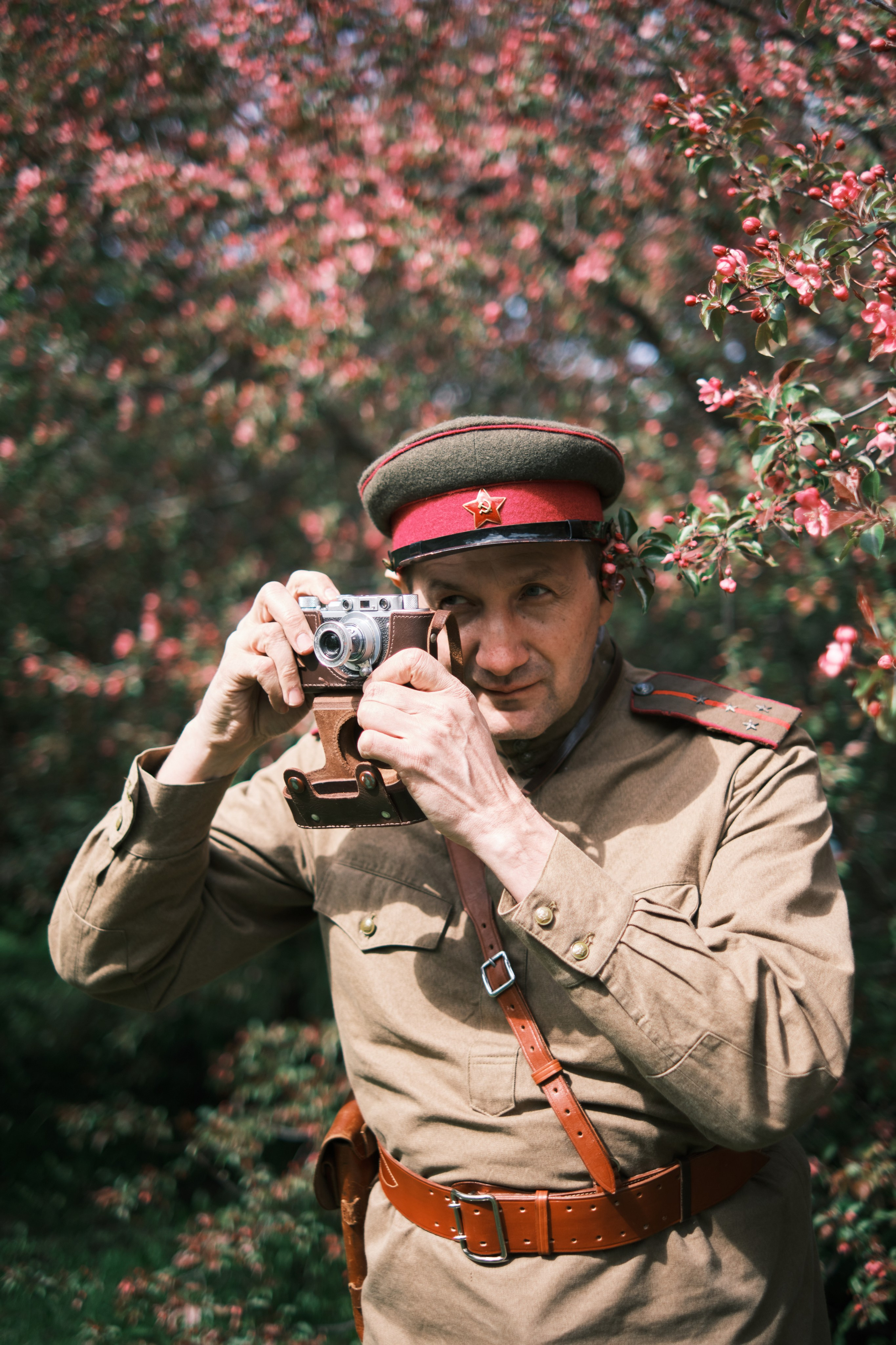 мужчина в военной форме фотографирует на старинный фотоаппарат