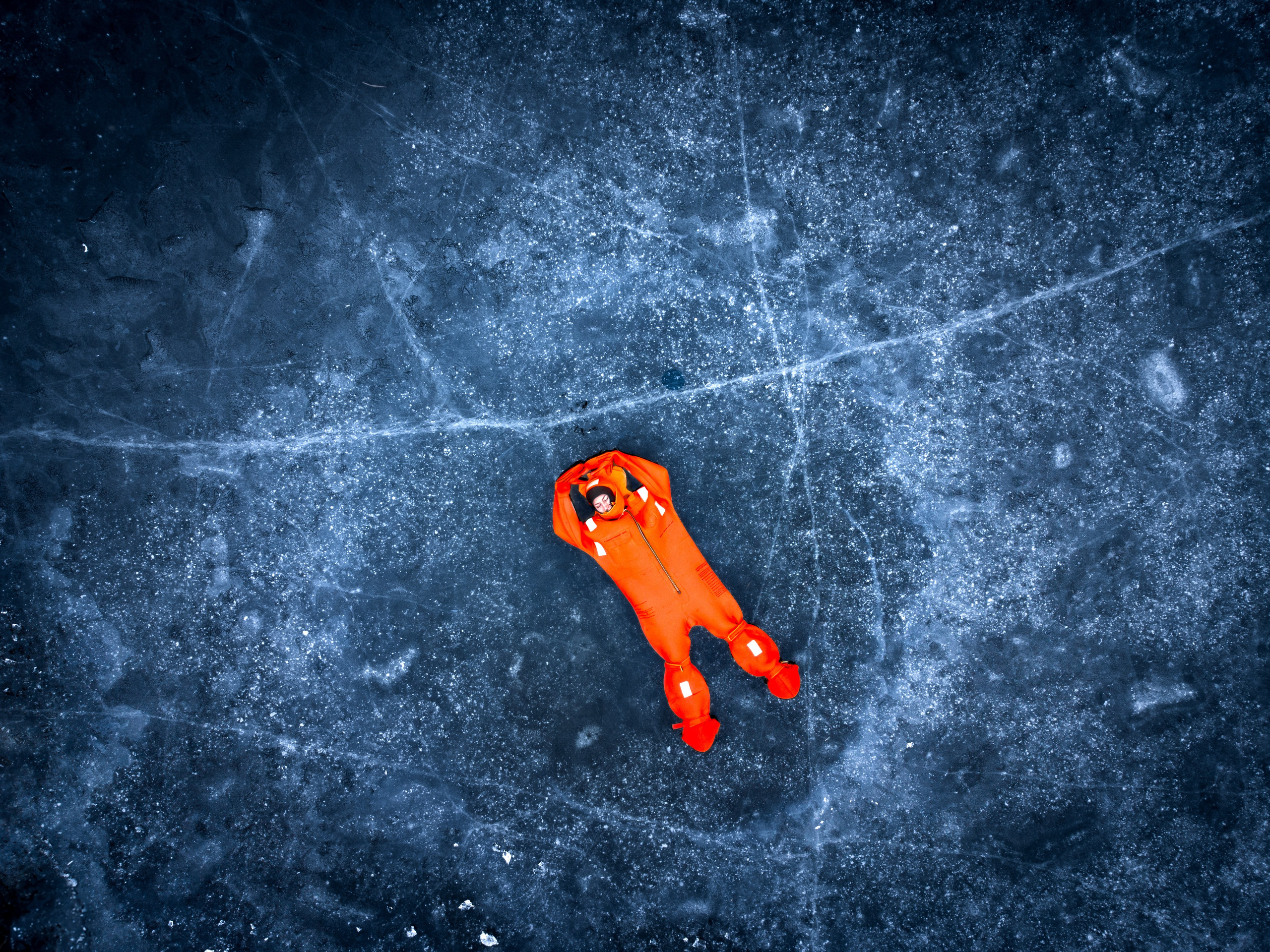 Люди купаются среди льдин, в спасательных оранжевых термо костюмах, айс флоатинг Ярославль