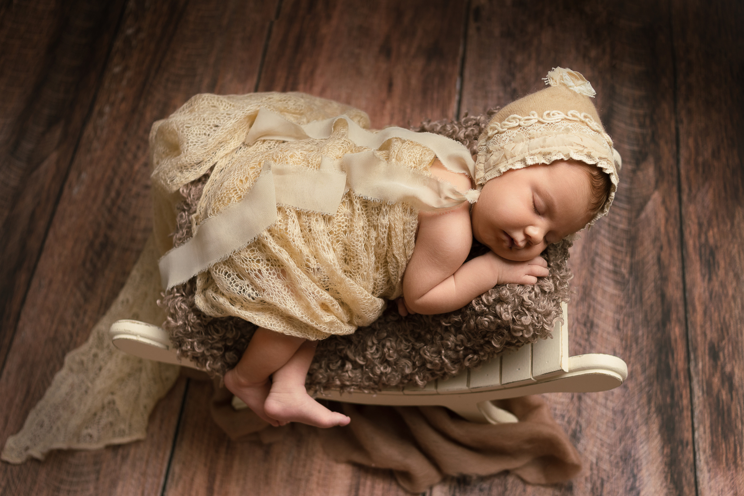 Позирование новорожденной девочки на кроватке с драпировкой