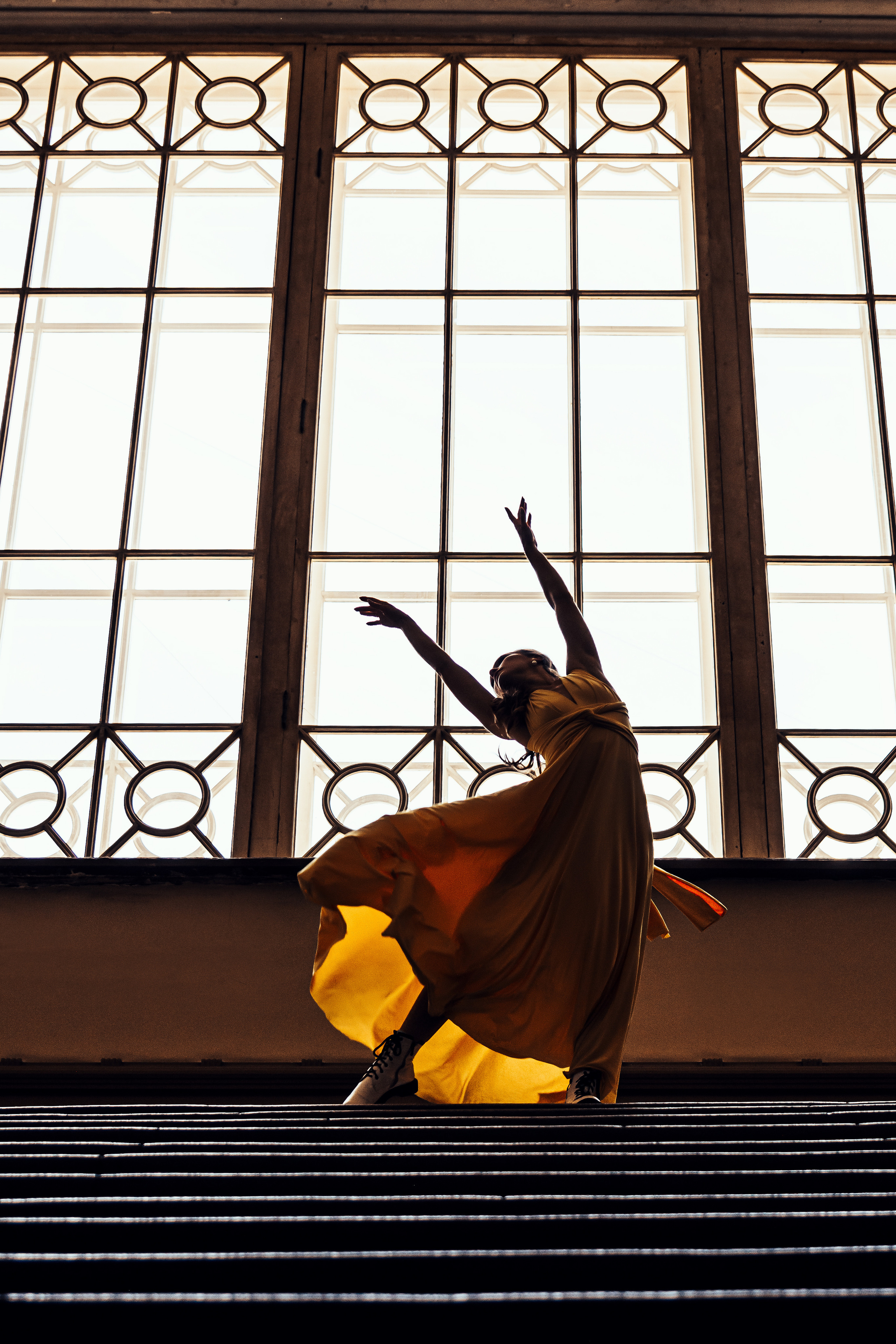 Артистичная девушка, грациозно танцующая в желтом платье на Витебском вокзале.