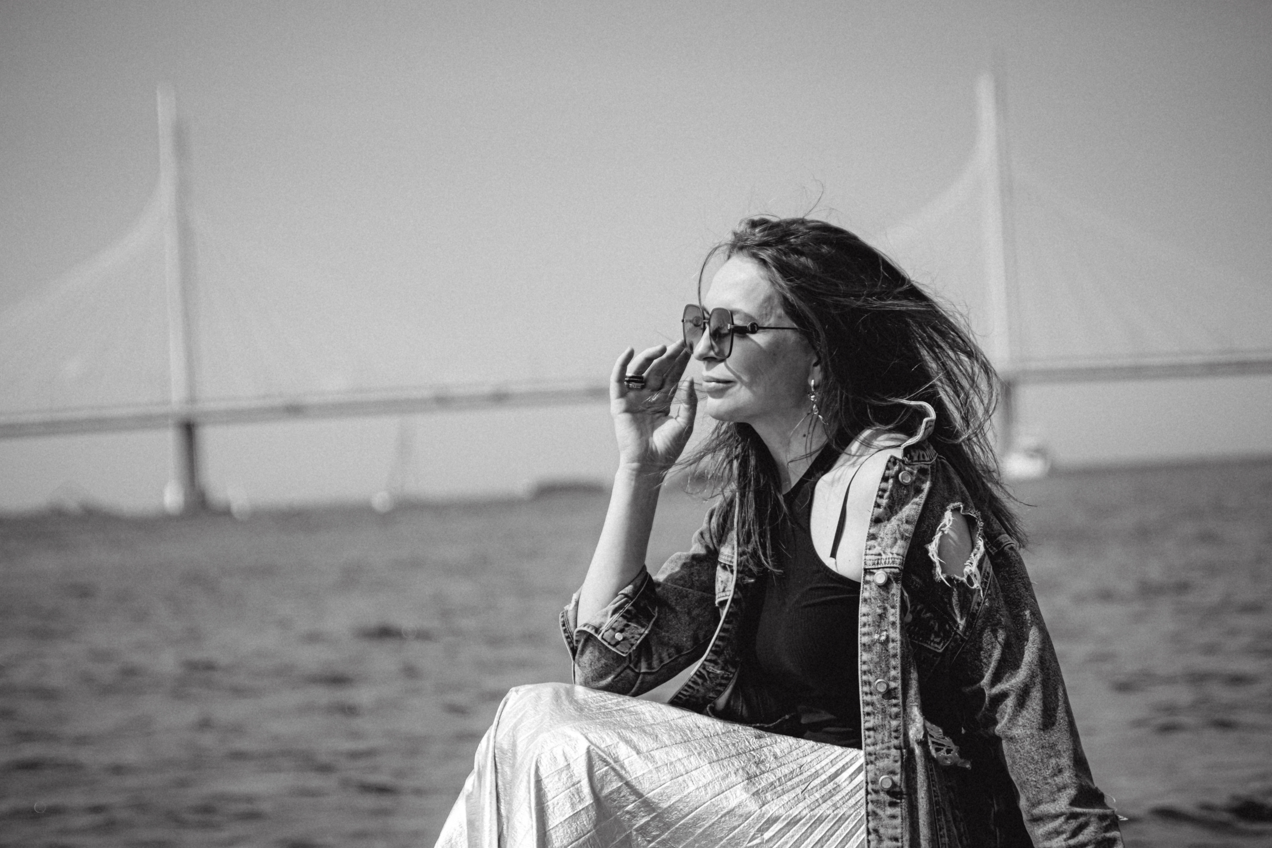 Мост на фоне, девушка стоит на камнях чб