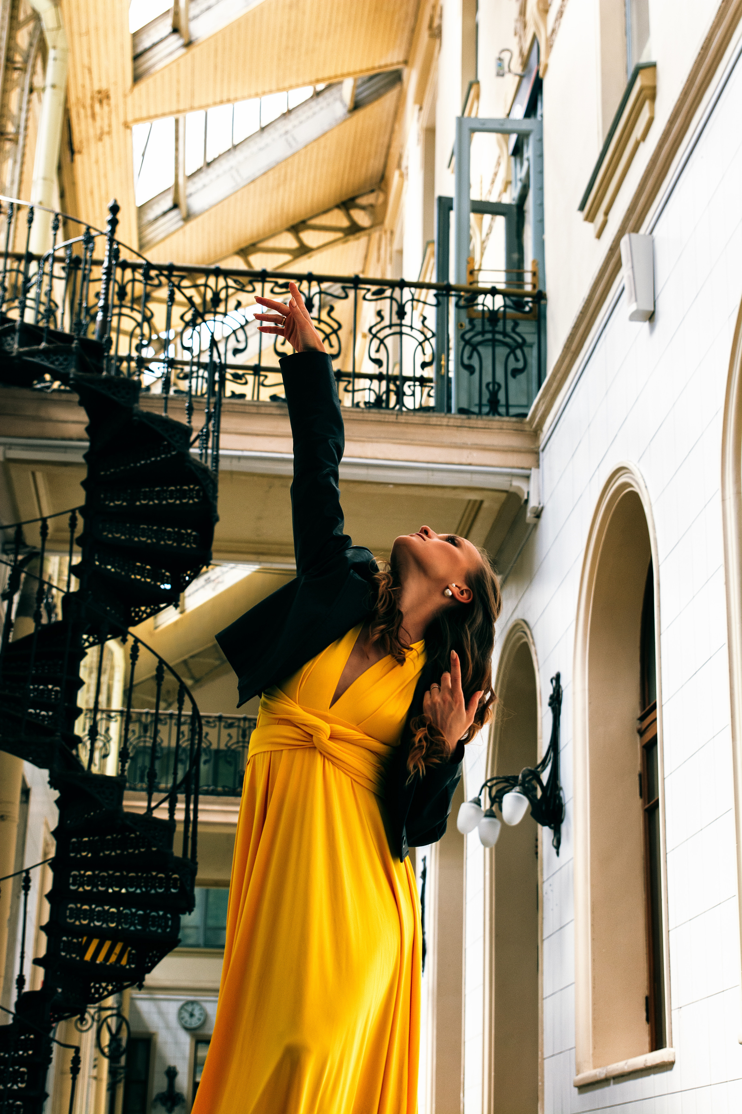 Артистичная девушка, грациозно танцующая в желтом платье на Витебском вокзале.