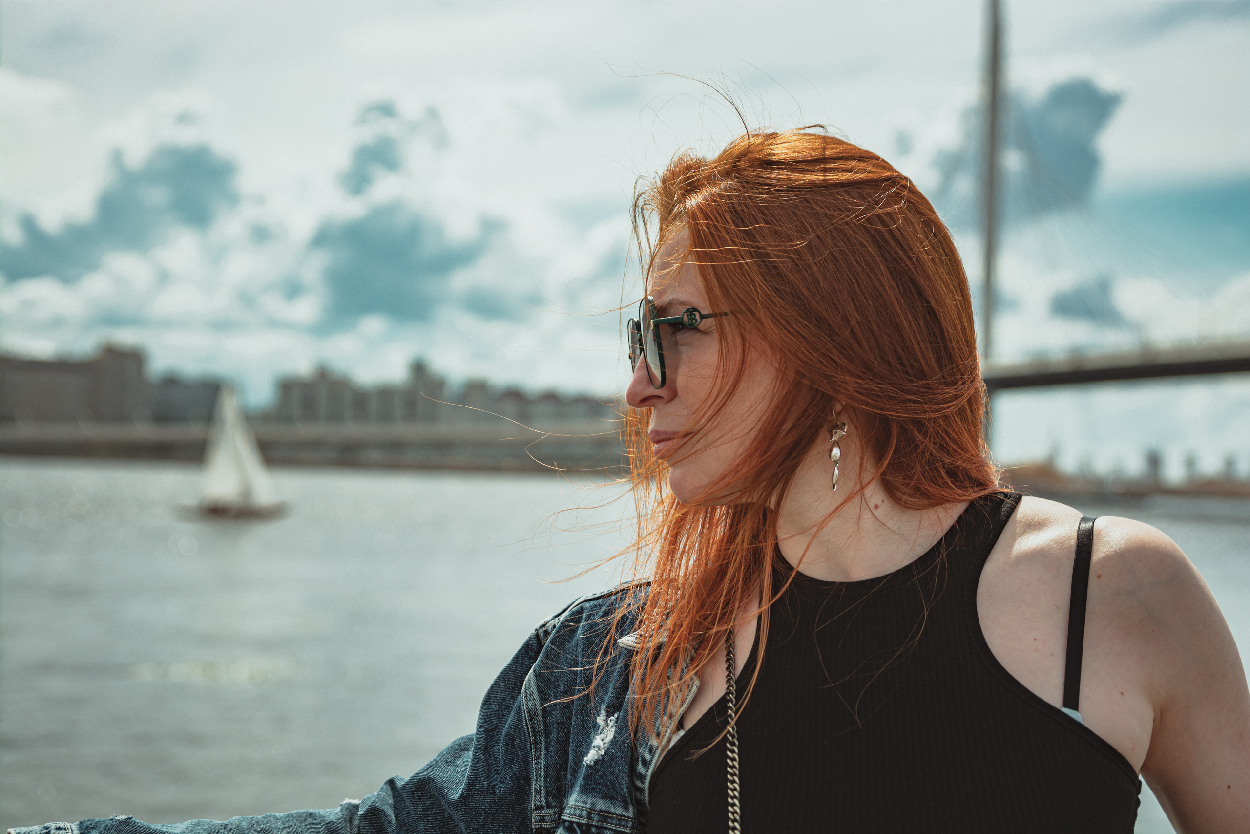 Рыжеволосая девушка на фоне парусник и мост