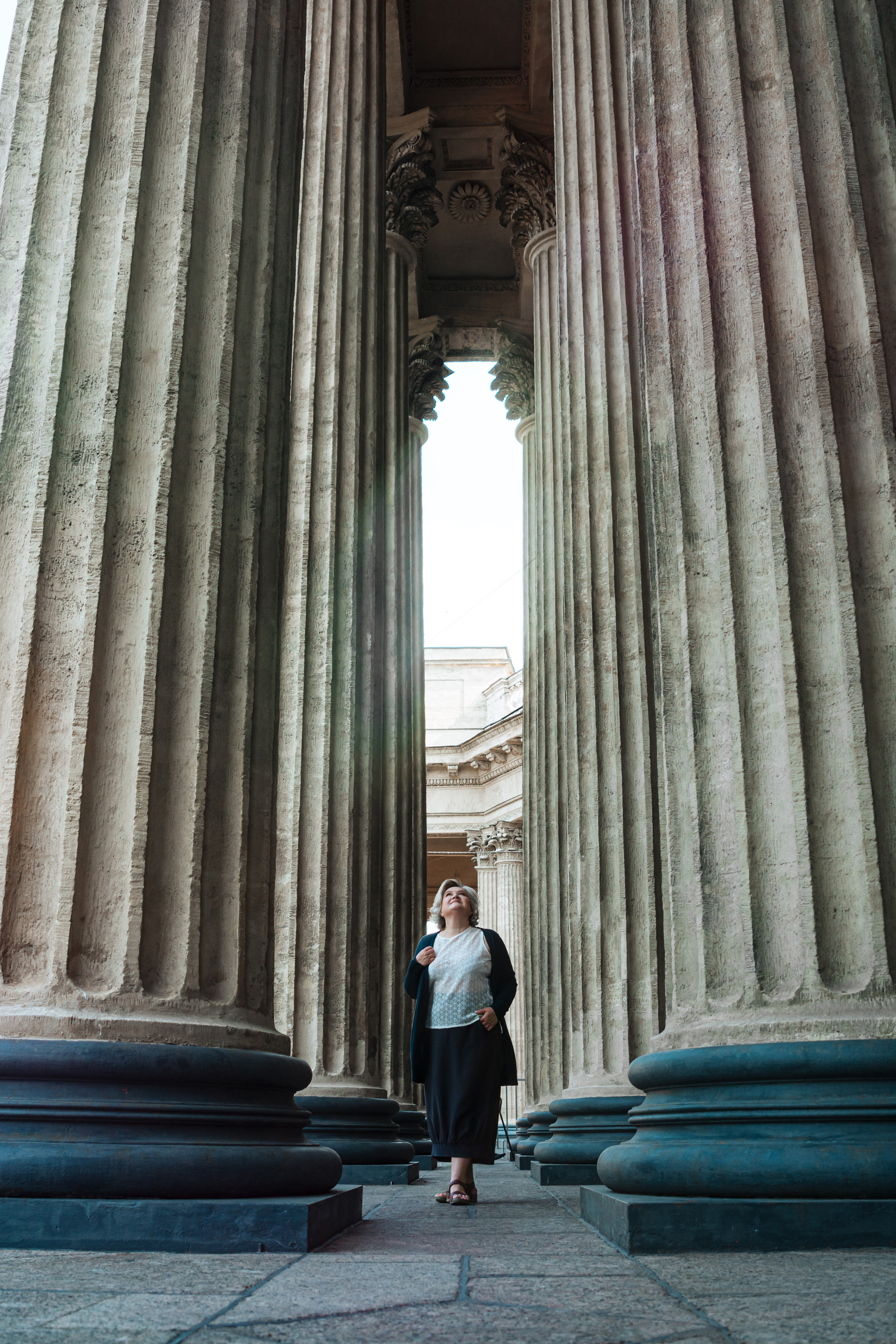 Женщина 60 лет, восхищающаяся Казанским собором и колоннами на улицах Санкт-Петербурга во время жаркого летнего дня.