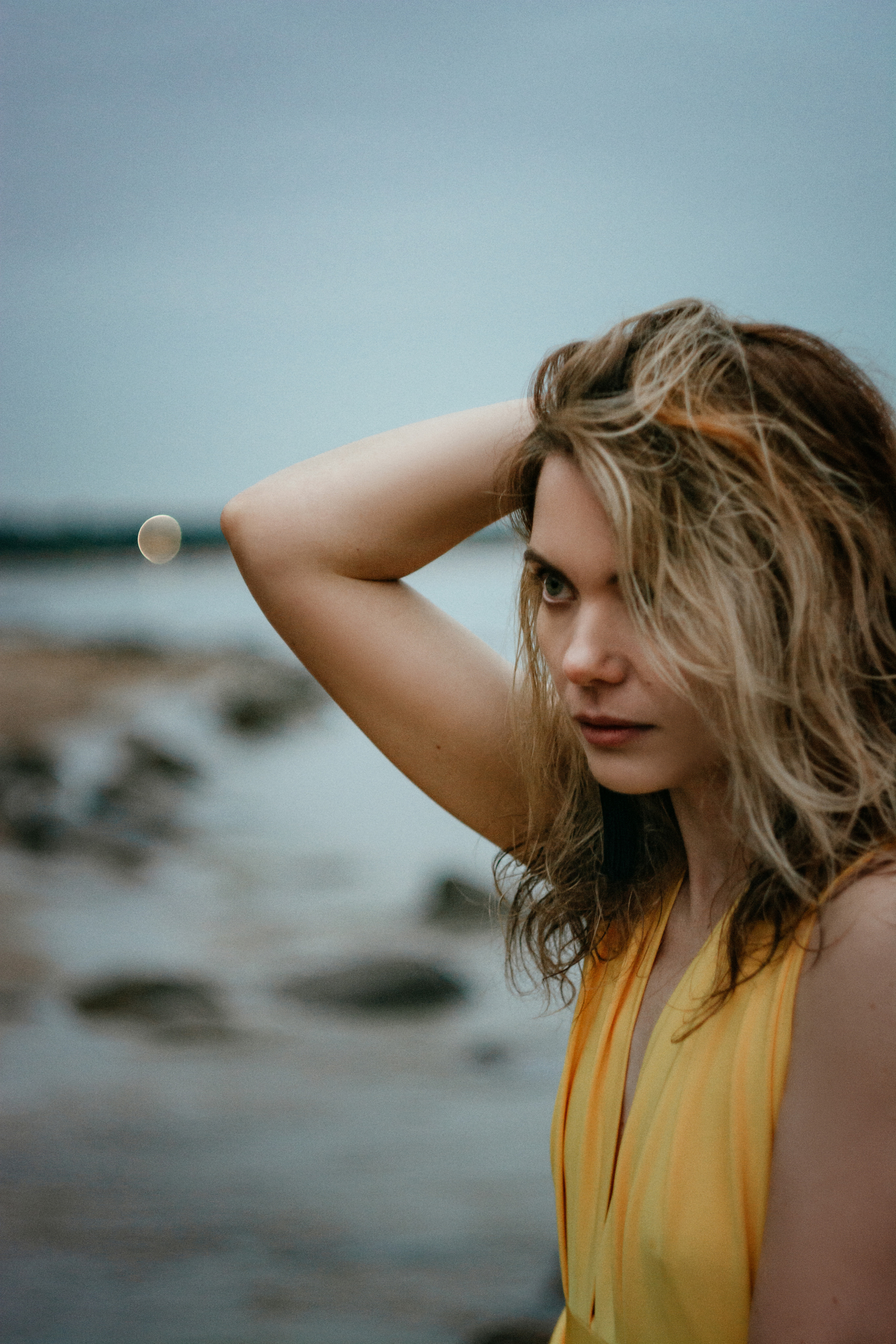 Эффектный портрет девушки в желтом платье, растворяющийся в сияющих оттенках заката на берегу Финского залива.