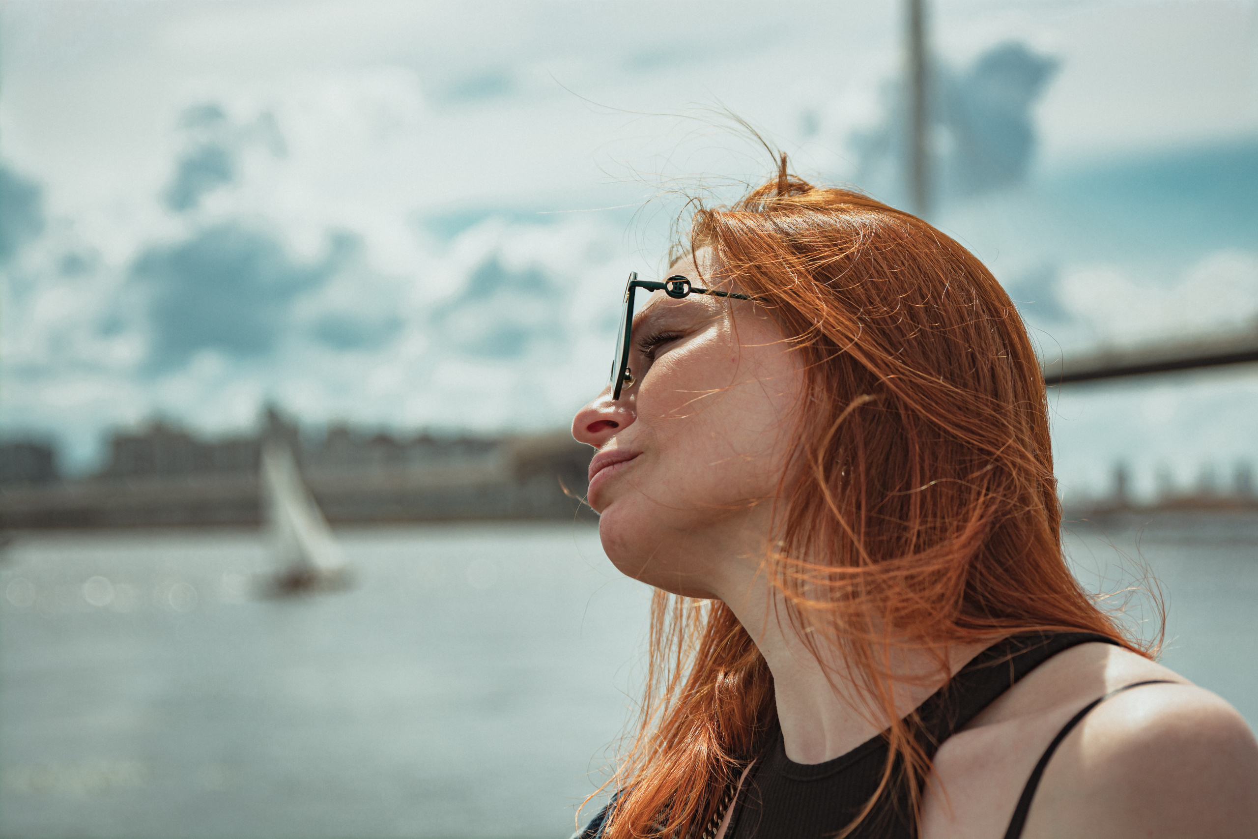 Рыжеволосая девушка на фоне парусник и мост