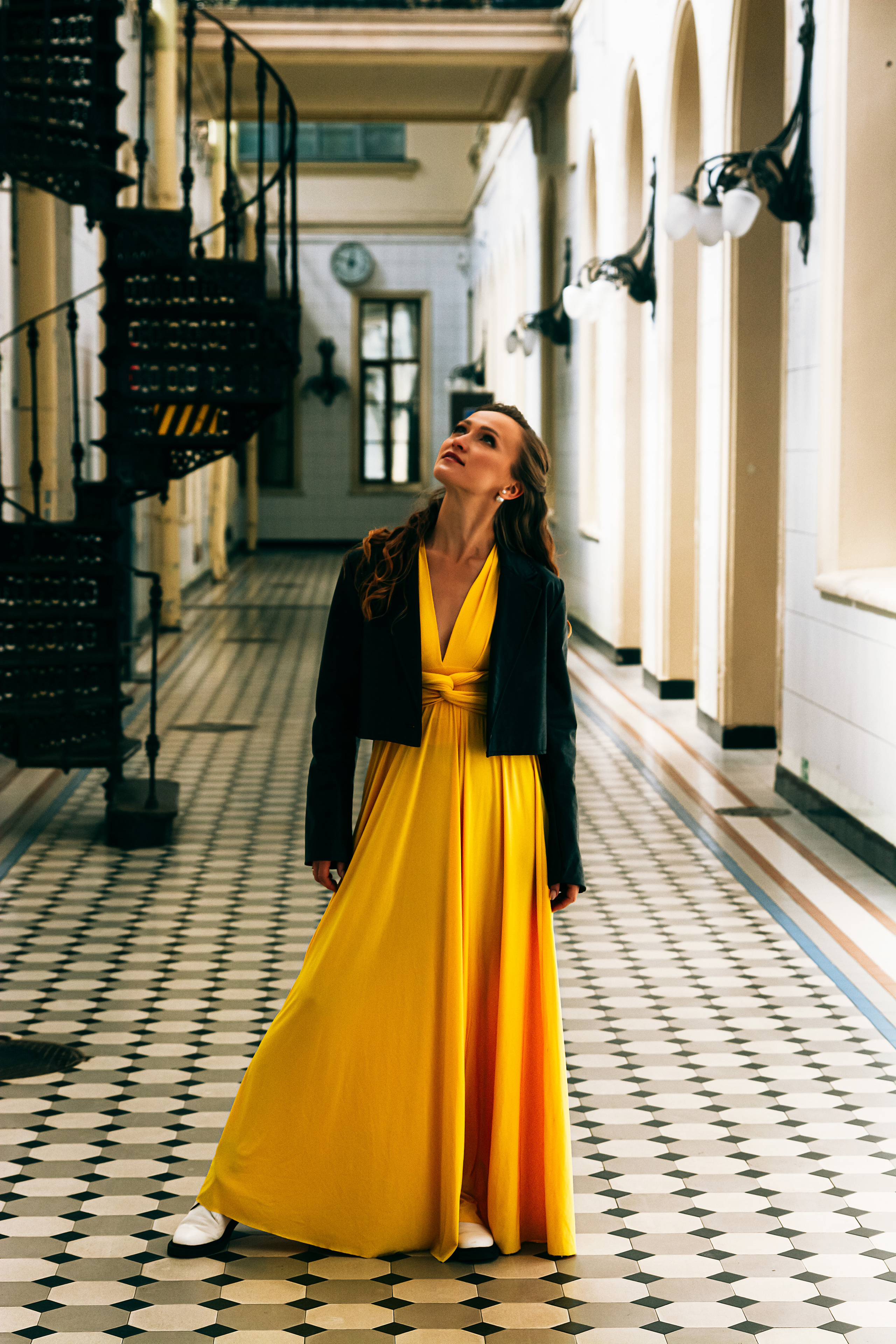 Артистичная девушка, грациозно танцующая в желтом платье на Витебском вокзале.