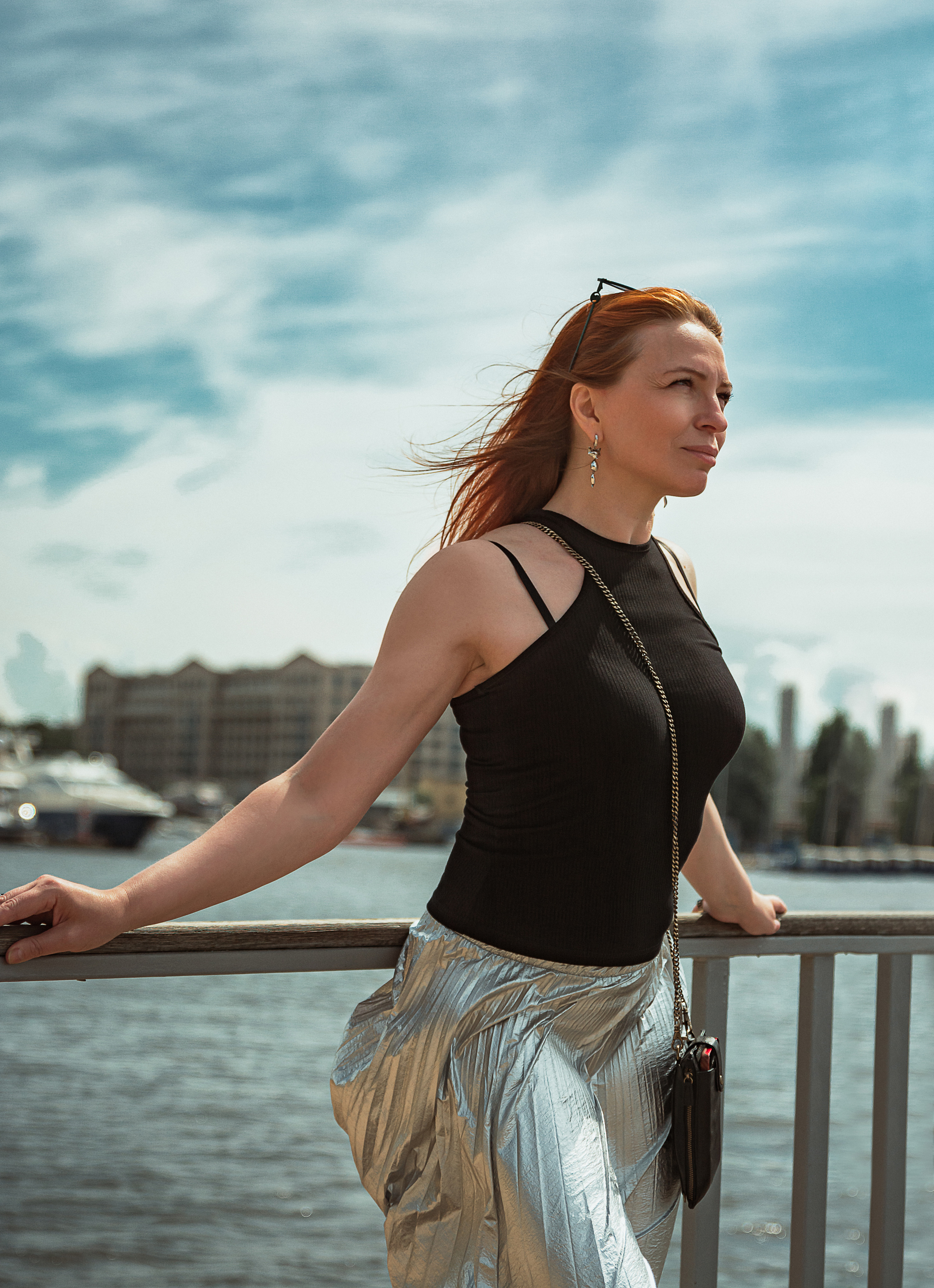 Рыжеволосая девушка стоит на пирсе