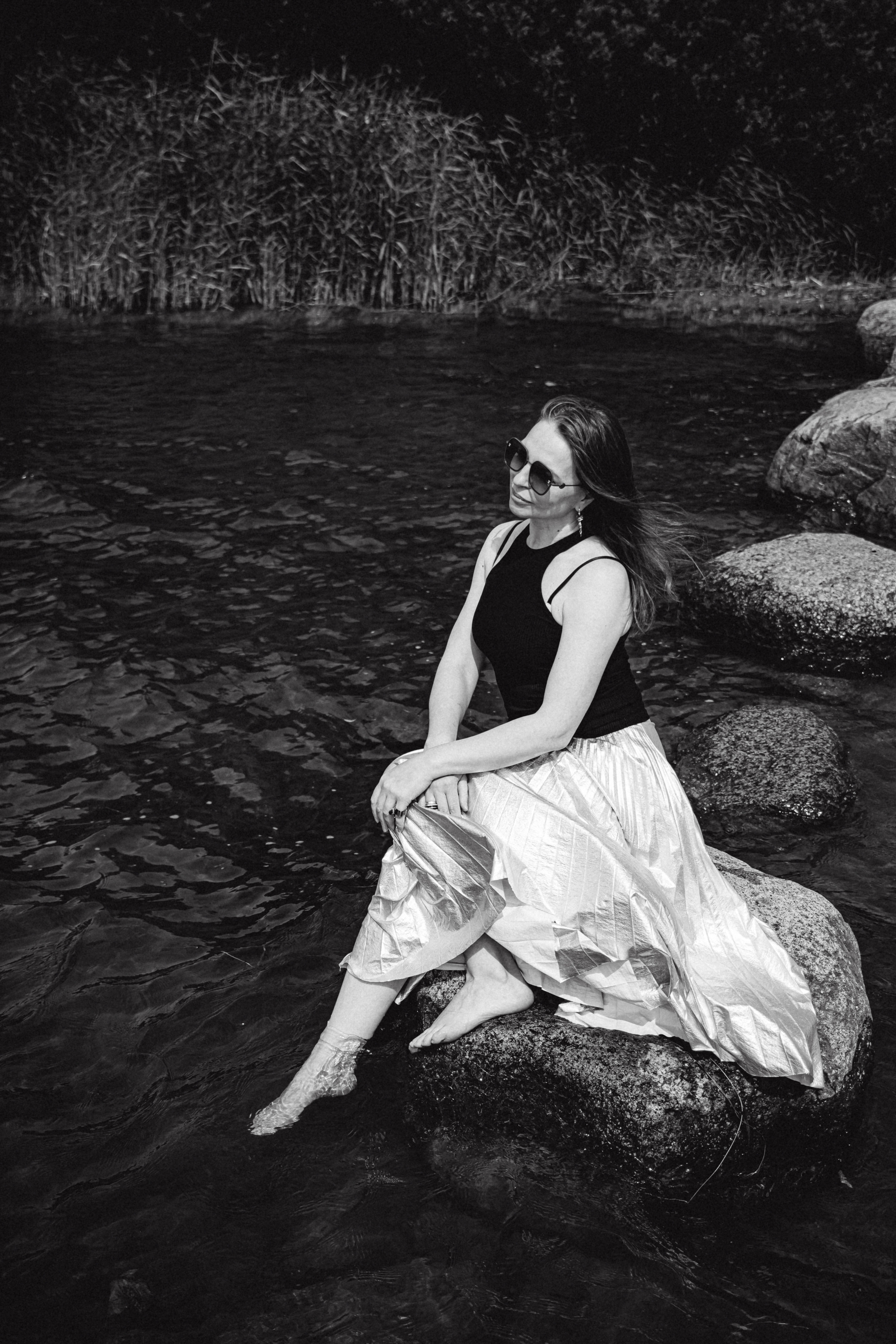 девушка сидит на камнях чб