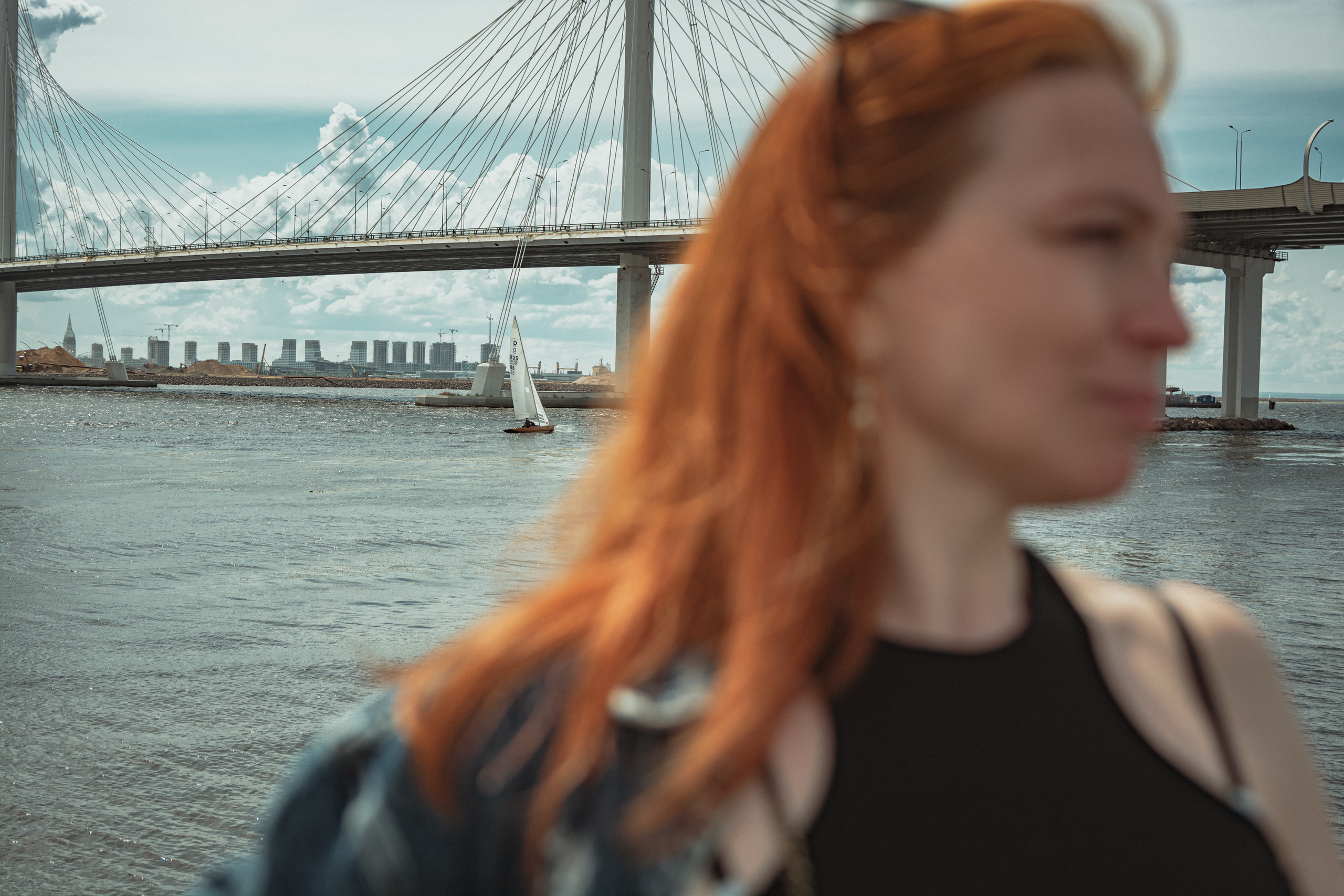 Рыжеволосая девушка на фоне парусник и мост