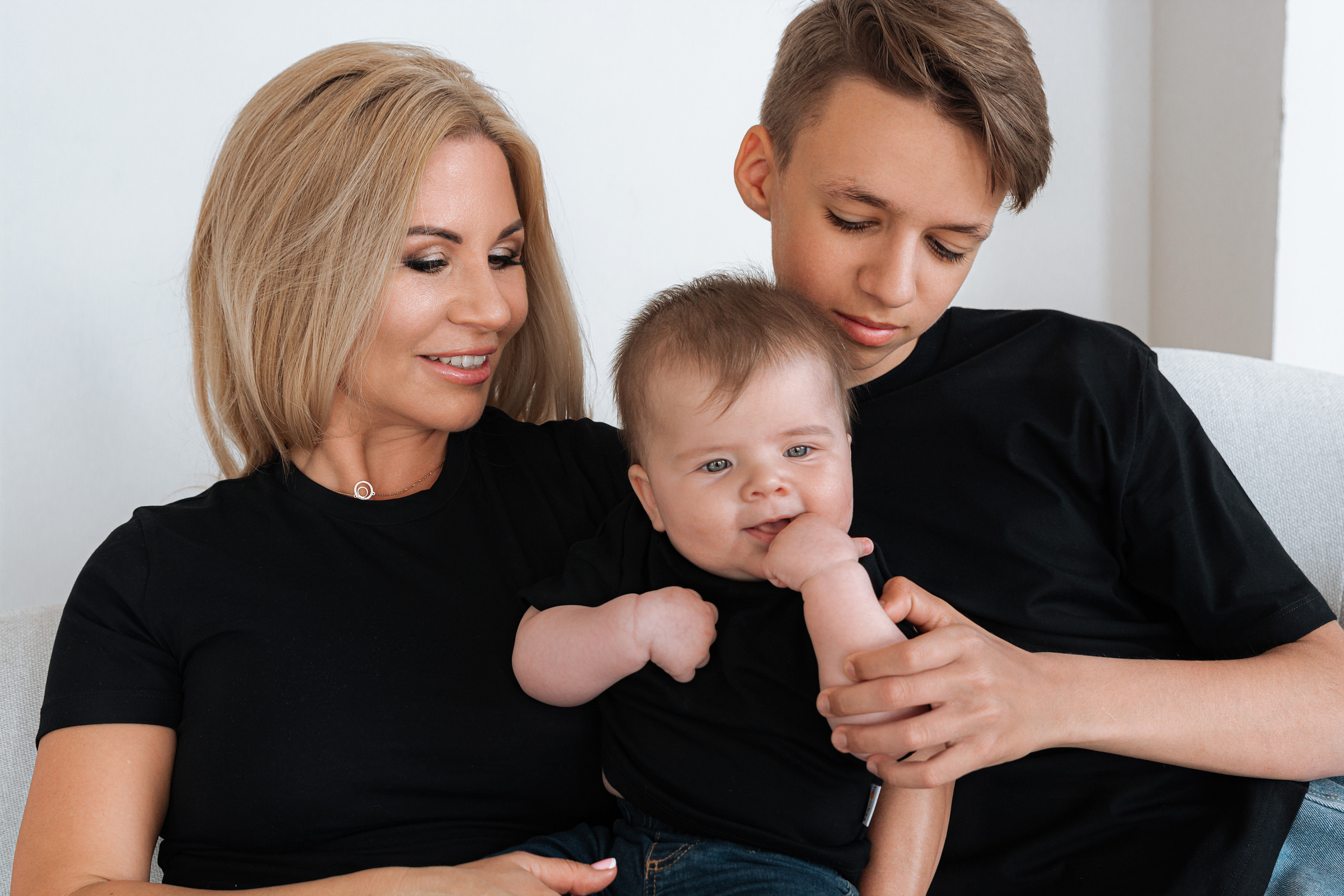 Лицо старшего брата наполнено радостью и гордостью, когда он держит свою маленькую сестренку за ручку.