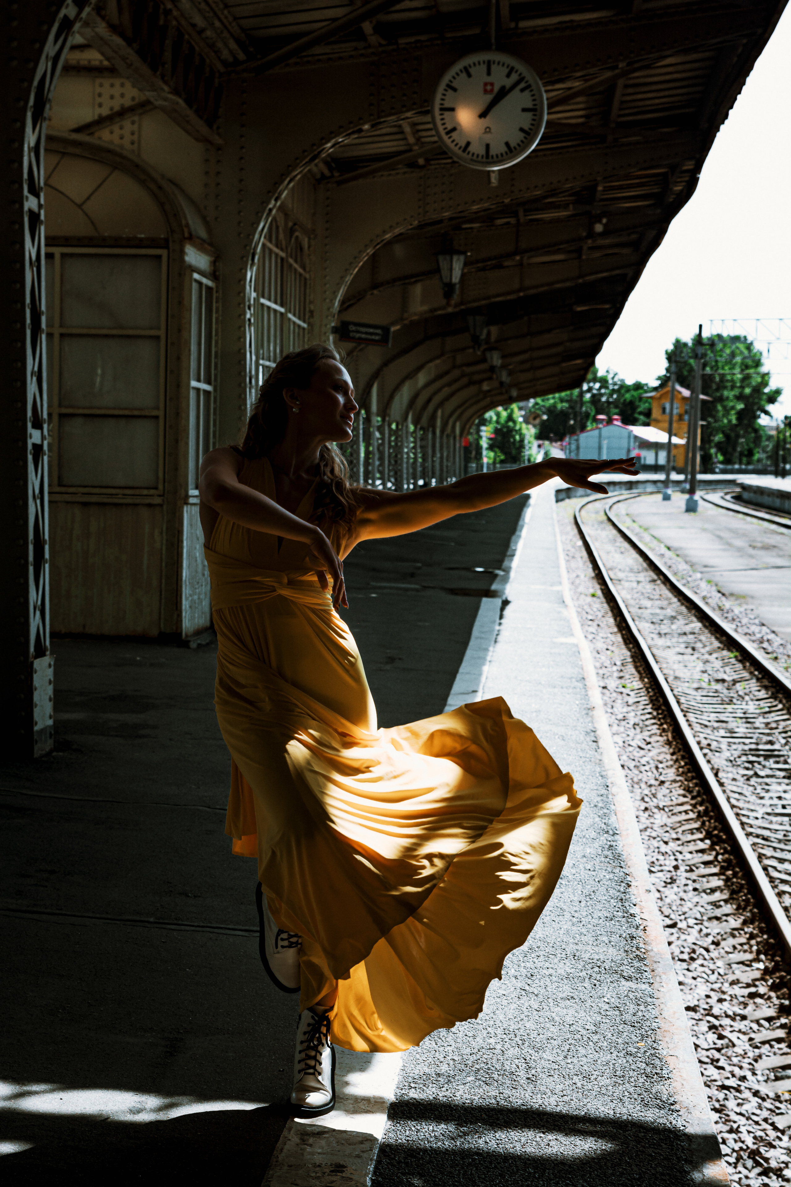 Яркая и стильная девушка, танцующая в желтом платье на Витебском вокзале.