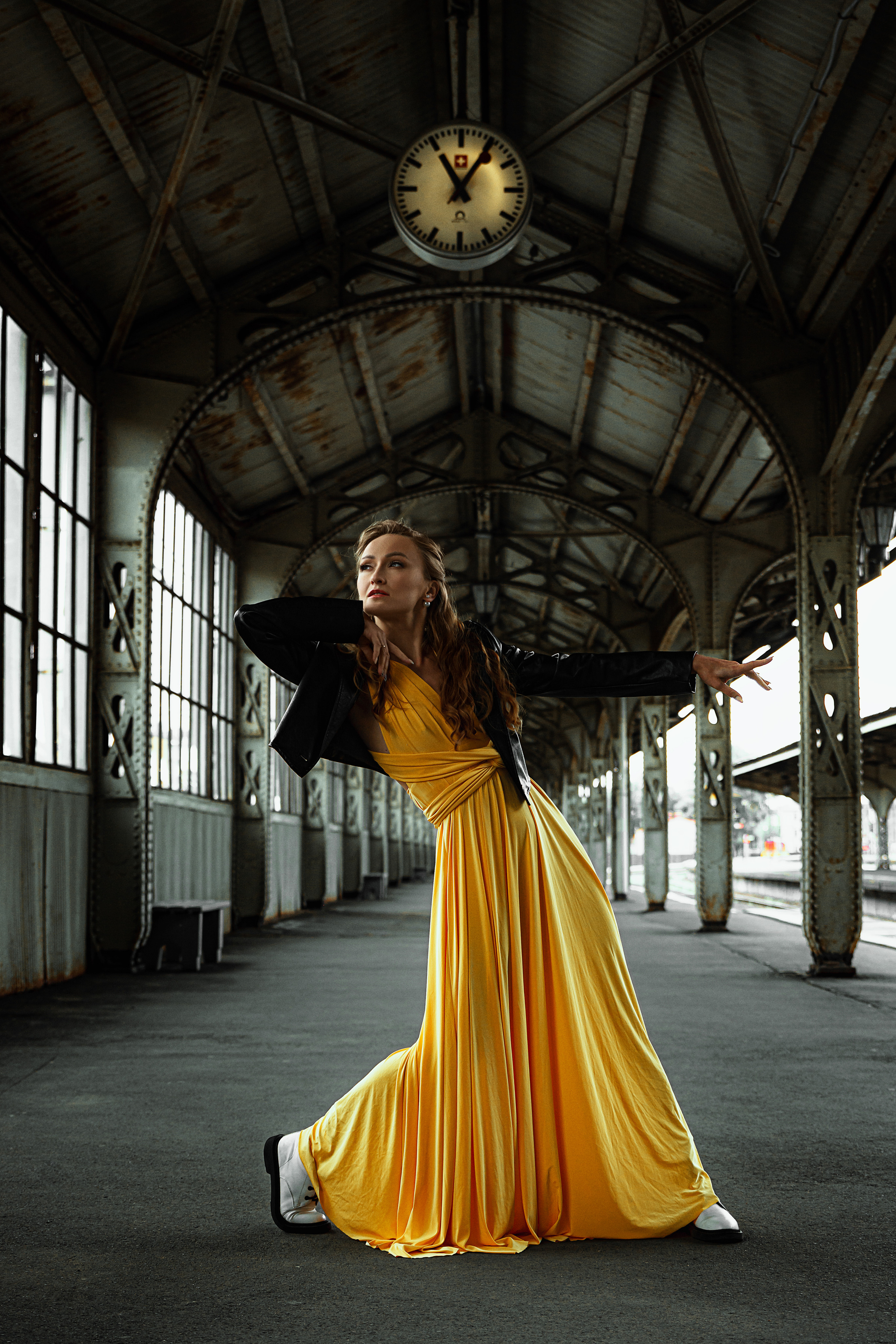 Витебское здание вокзала становится фоном для грациозного выступления девушки-танцовщицы в желтом платье.