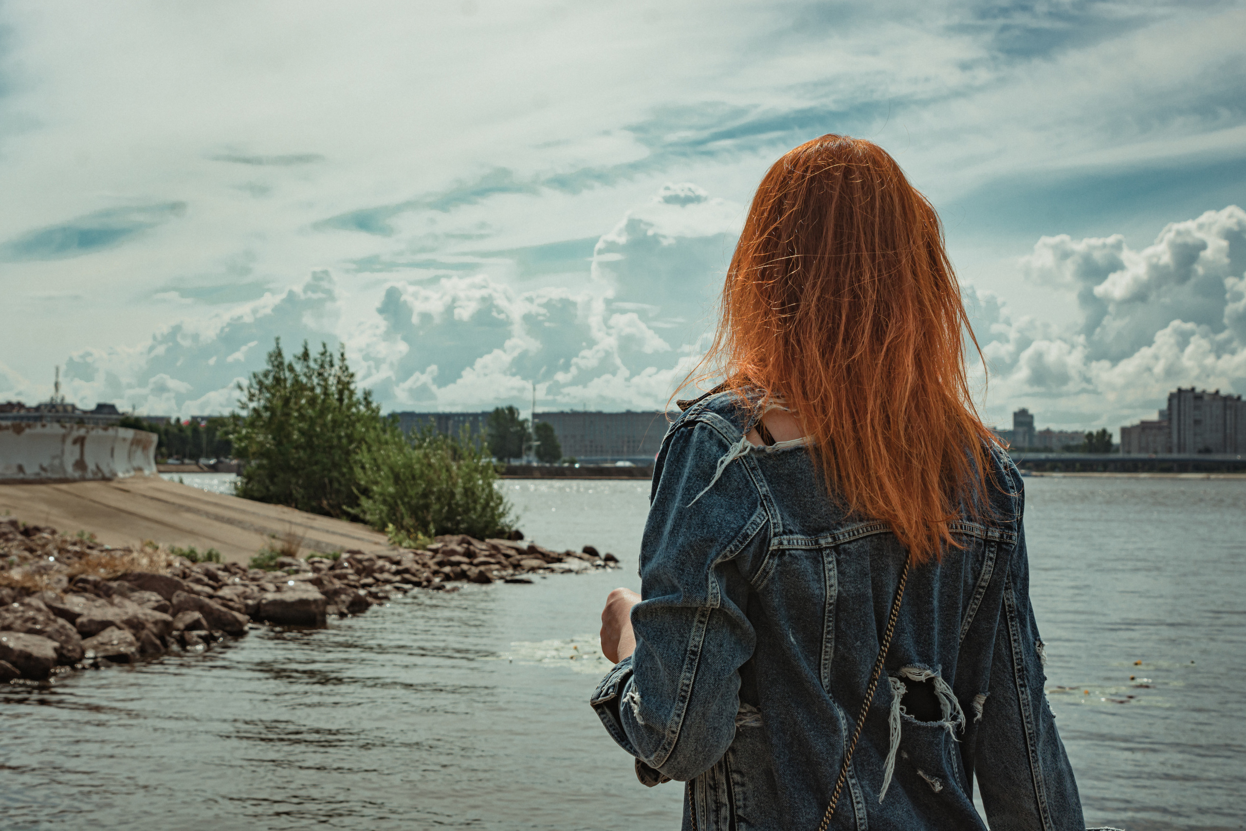 девушка со спины на берегу камни