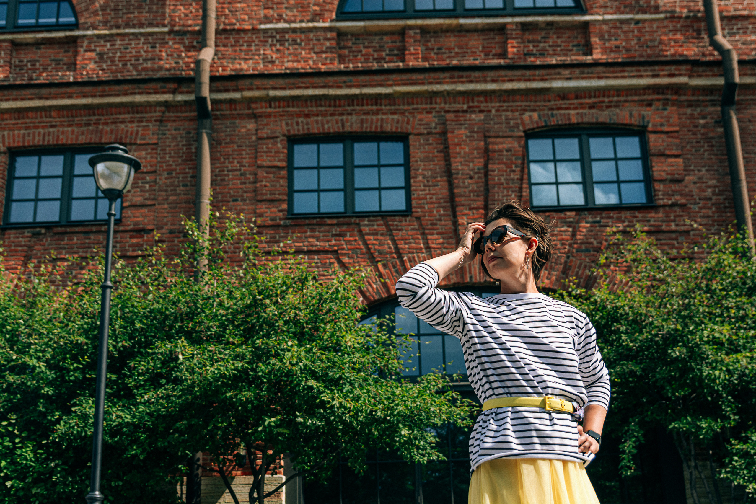 Раскрывая свою индивидуальность стильным образом, девушка в жёлтой юбке и тельняшке исследует Новую Голландию в Петербурге.