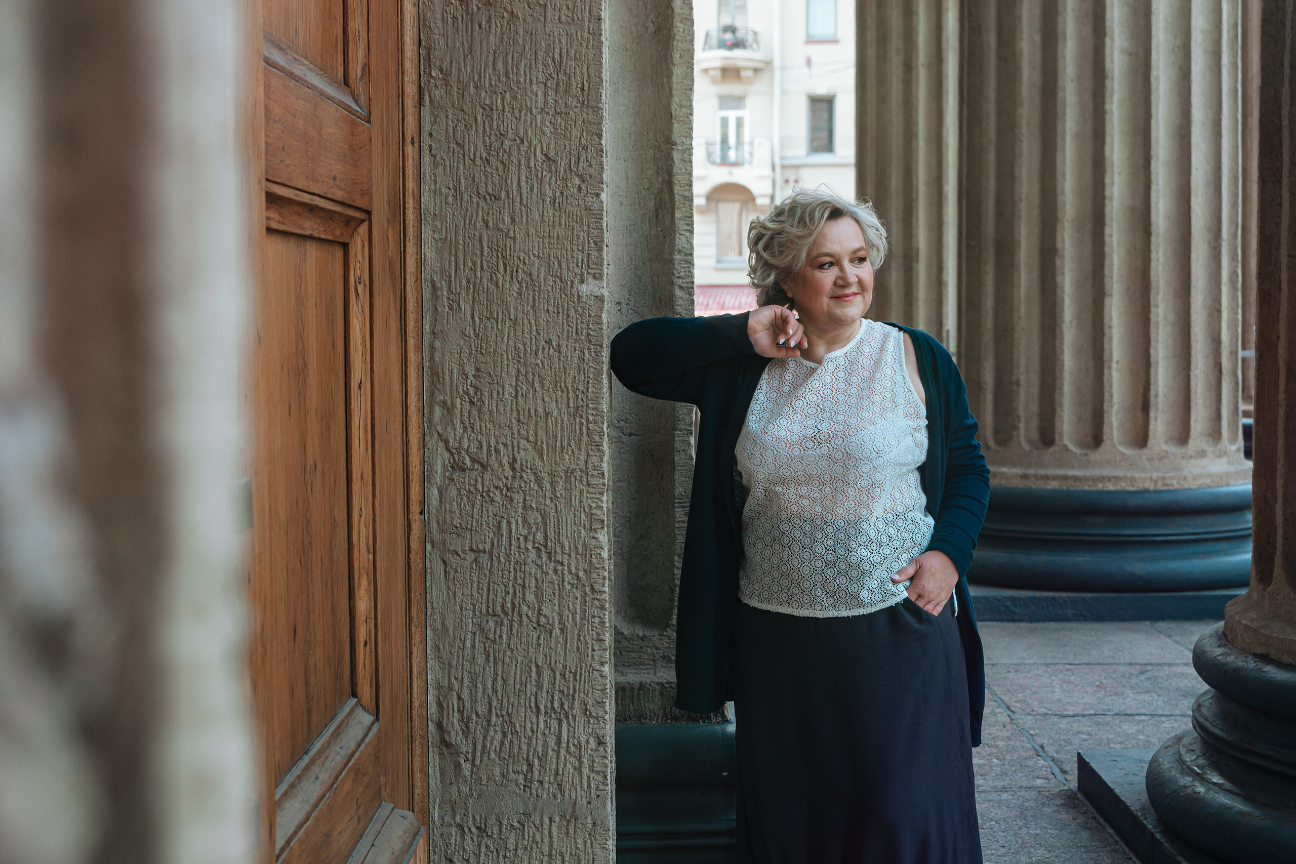 Улыбающаяся женщина средних лет, наслаждающаяся жарким летним днем в городе Санкт-Петербург, Казанский собор