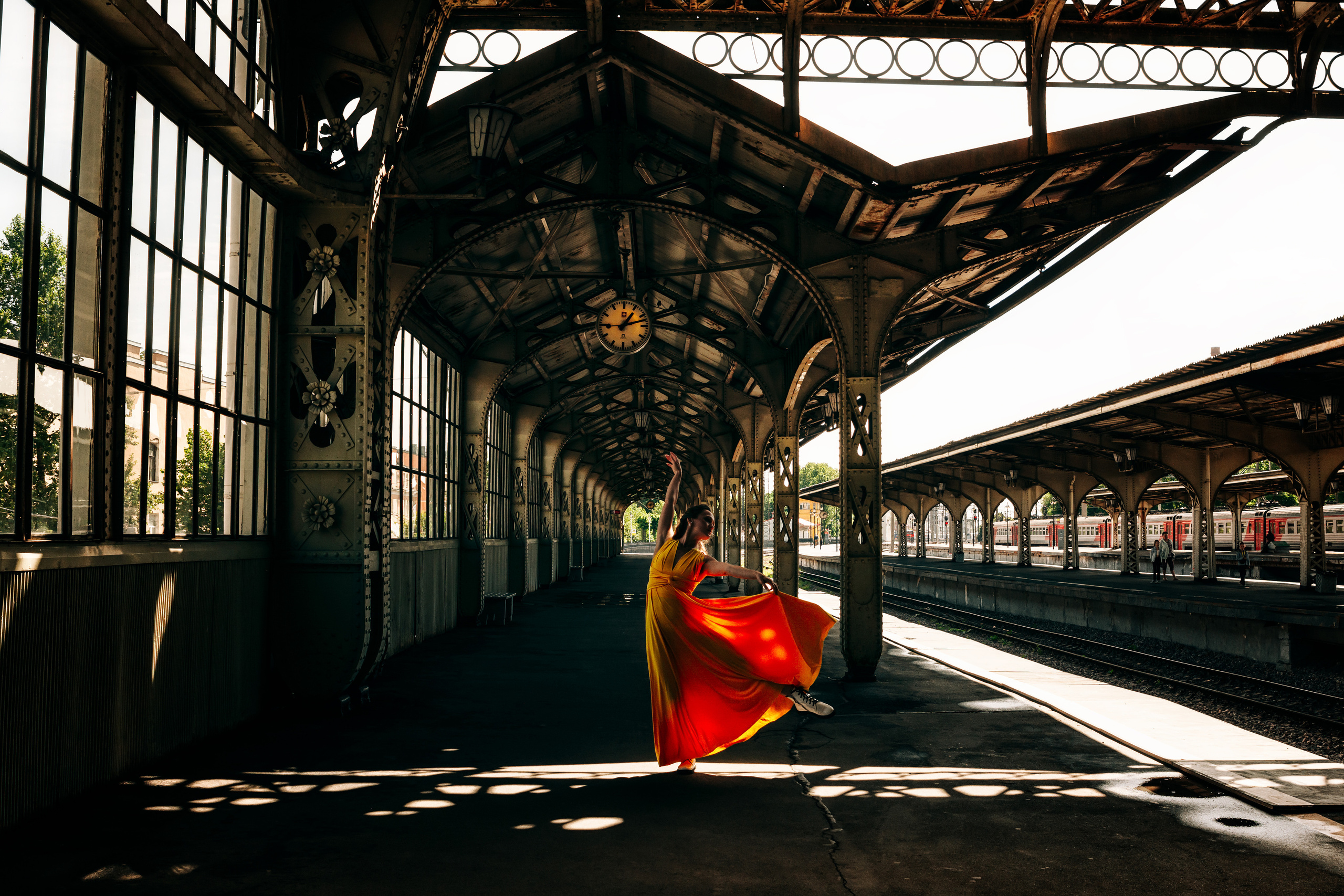 Яркая и стильная девушка, танцующая в желтом платье на Витебском вокзале.