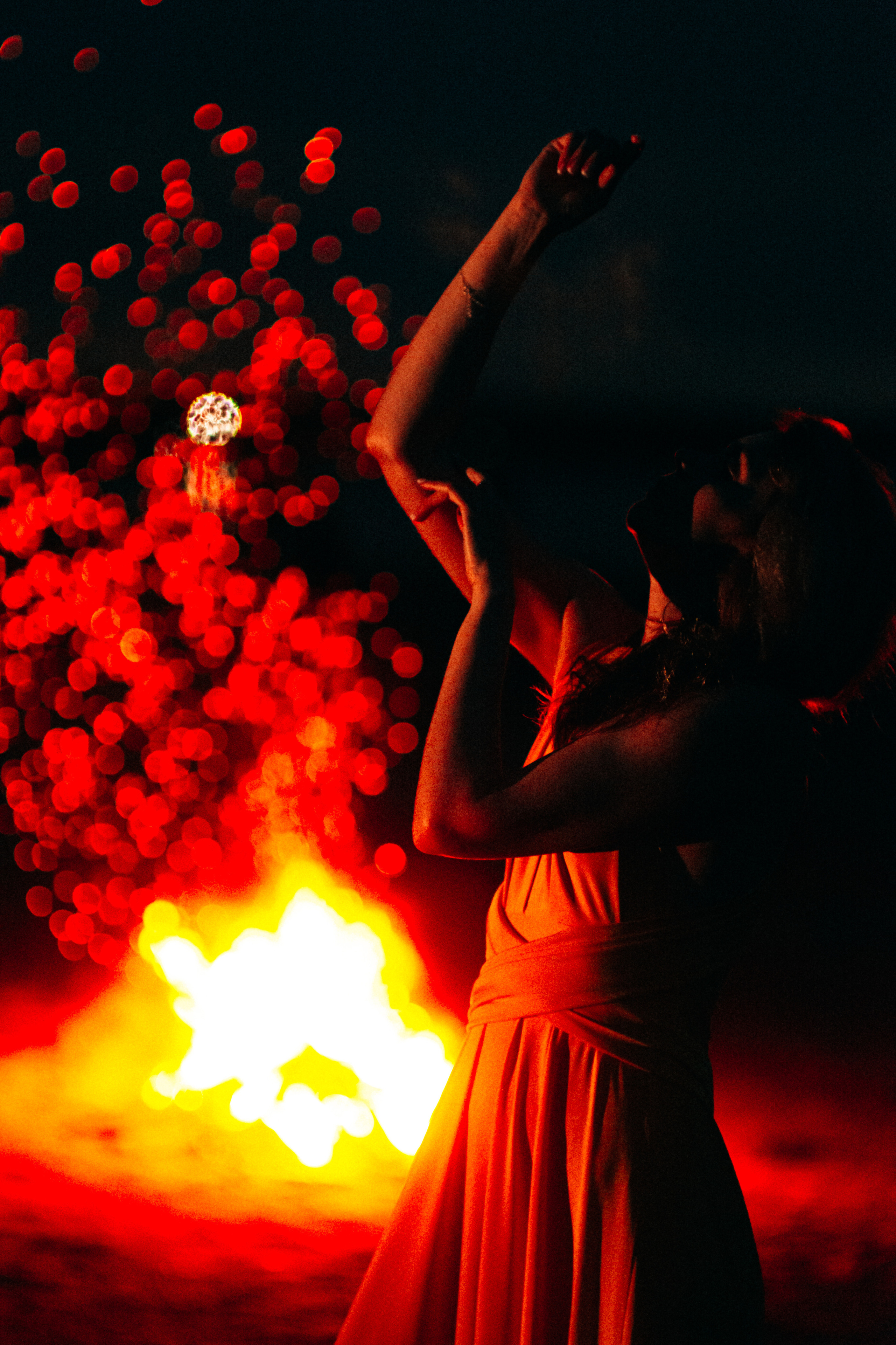 Костер создает захватывающий фон, обрамляющий девушку в желтом платье и придавая ей таинственность и привлекательность.