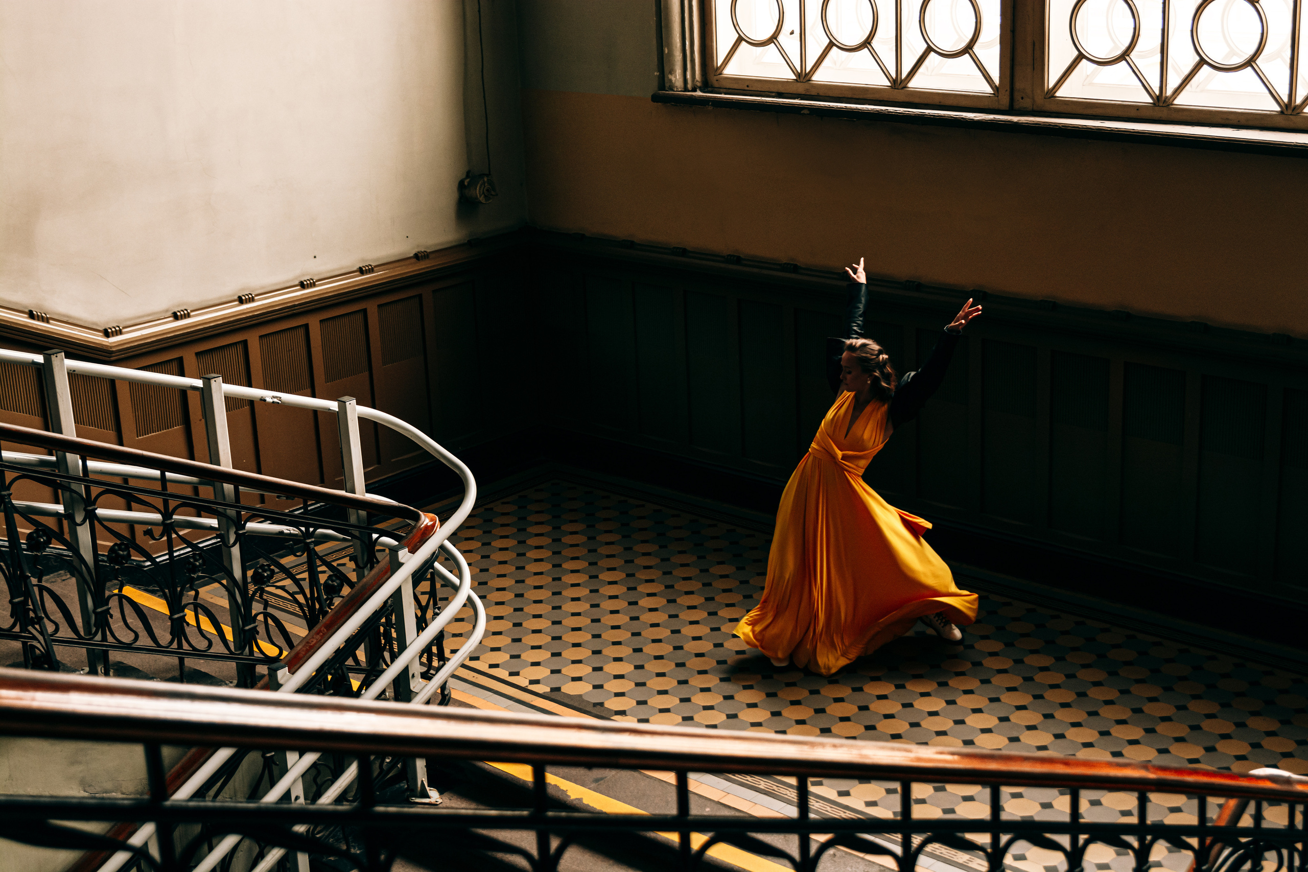 Эффектные танцевальные движения в огненном желтом платье делают выступление девушки на Витебском вокзале незабываемым.