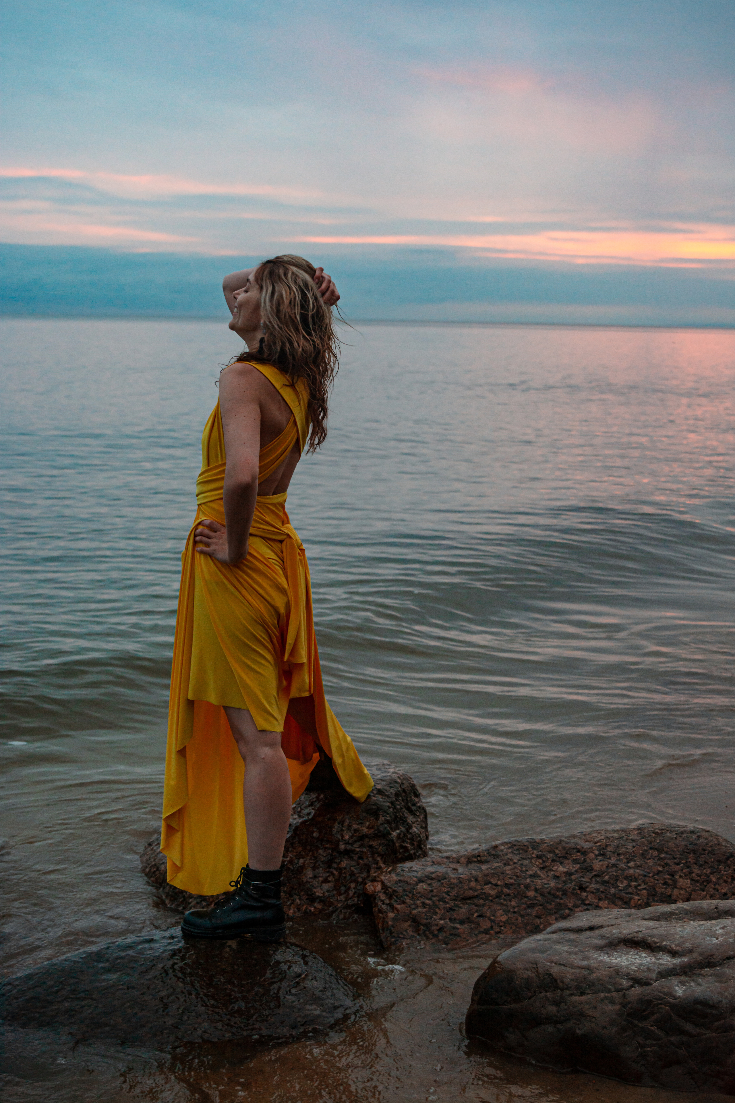 Фотосессия на берегу Финского залива запечатлевает девушку в ярком желтом платье, на фоне многоцветного заката, олицетворяющего ее внутреннюю красоту.